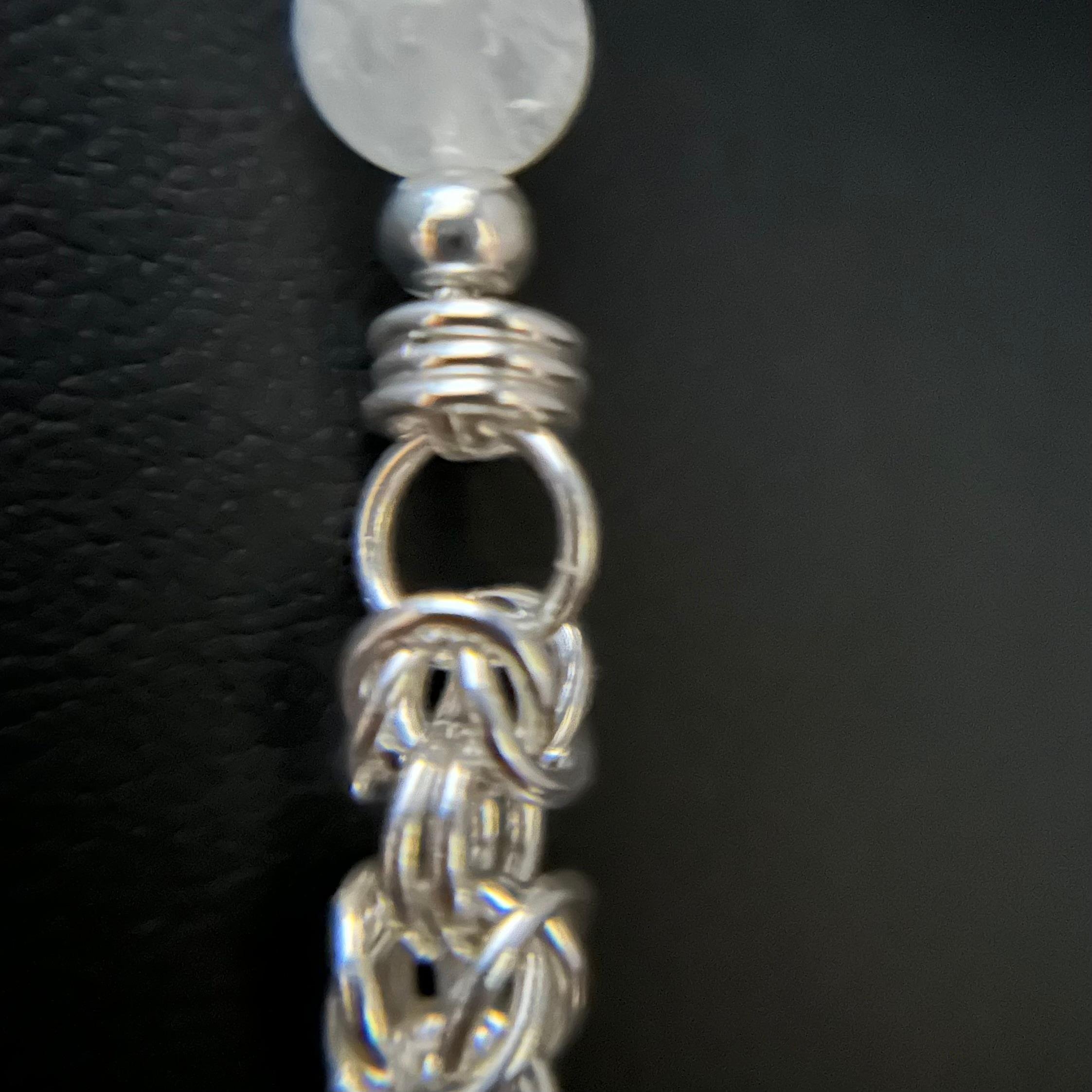 Detailed close-up of the handwoven Byzantine sterling silver chain section on the Silver Starlight necklace.
