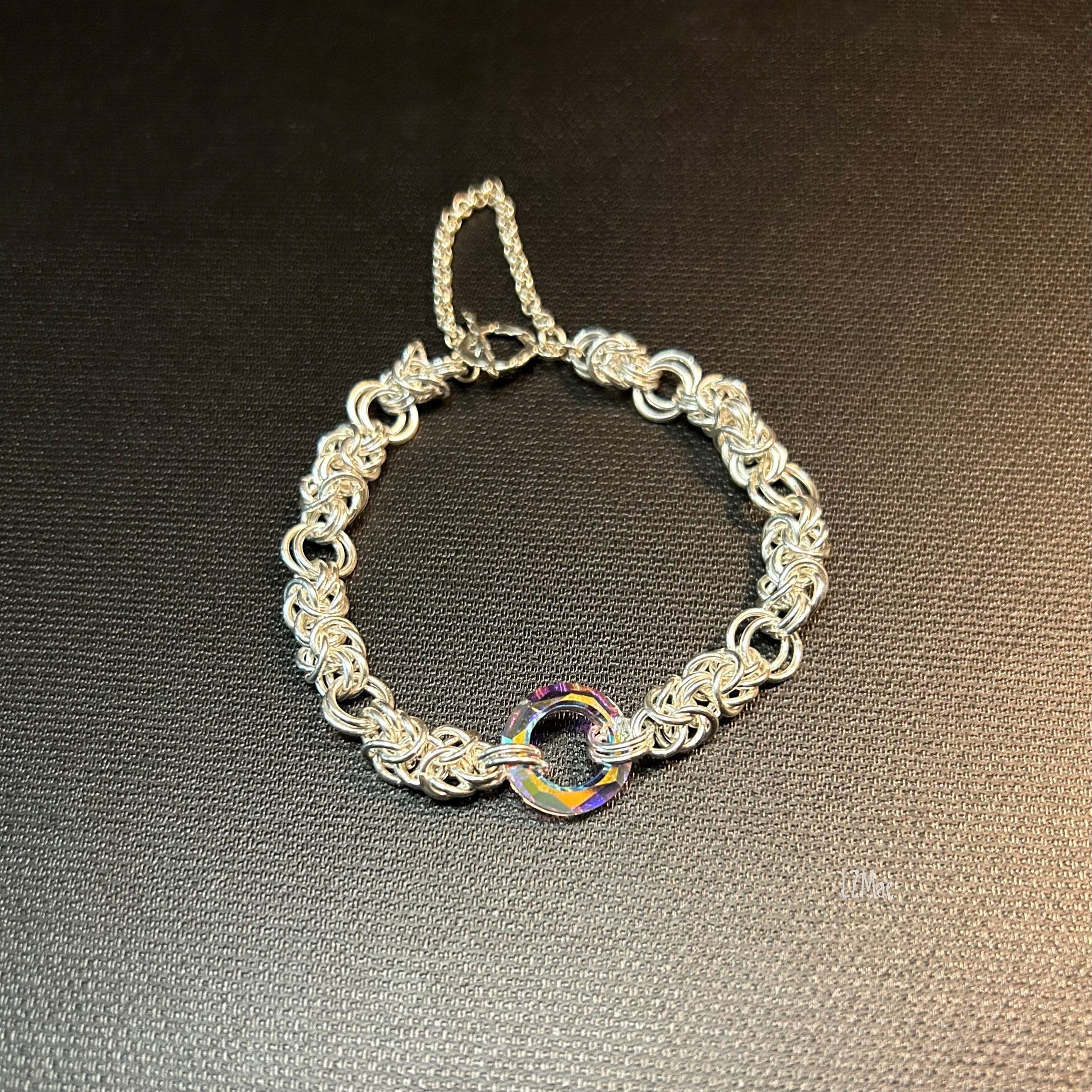 Sterling Silver Byzantine bracelet “Silver Halo” shown flat with a single Swarovski crystal donut centerpiece. showing the blue side of the crystal
