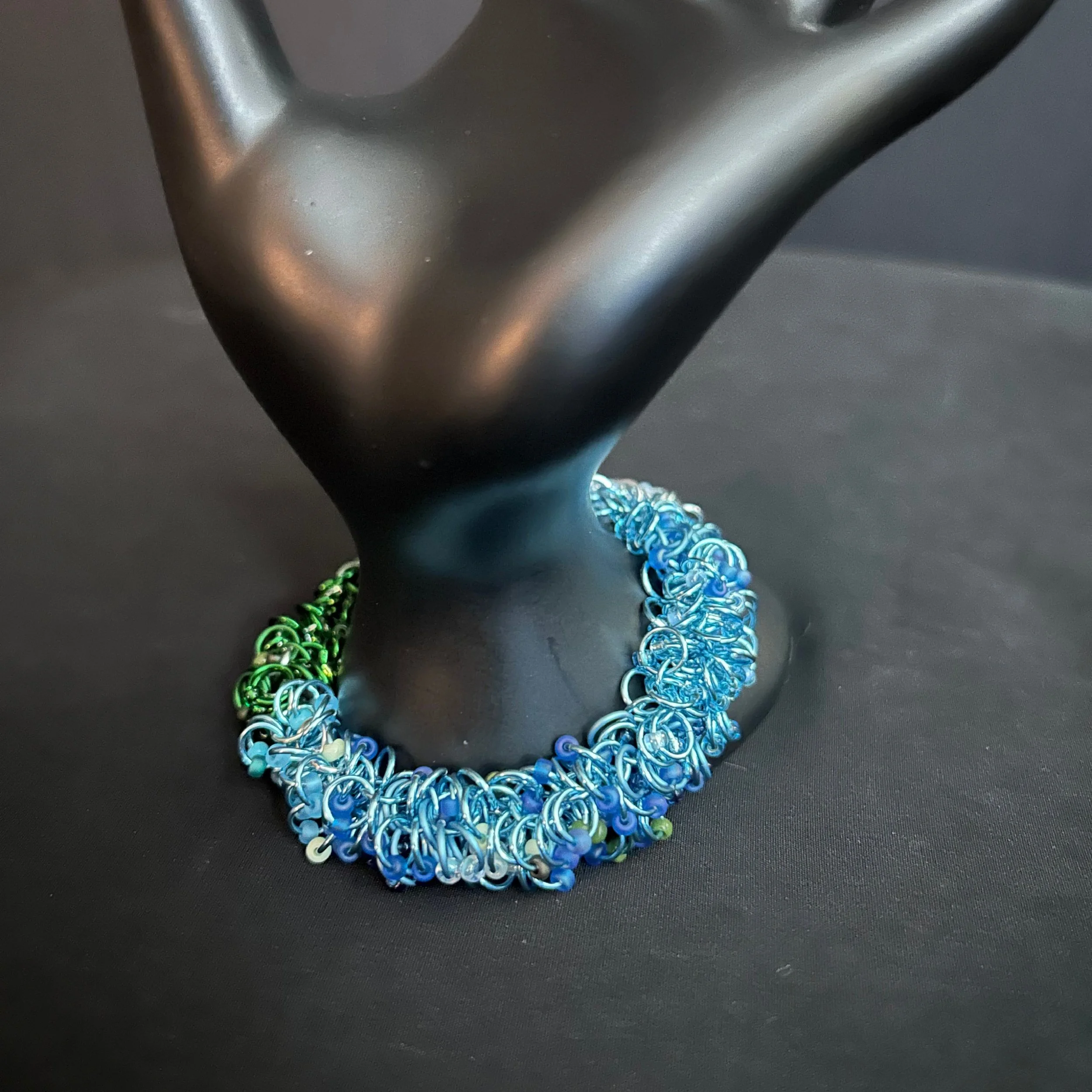 “Blue Ridge Mountain bracelet displayed on a hand prop showing the green‑to‑blue bead gradient.”“Blue Ridge Mountain bracelet displayed on a hand prop showing the green‑to‑blue bead gradient.”