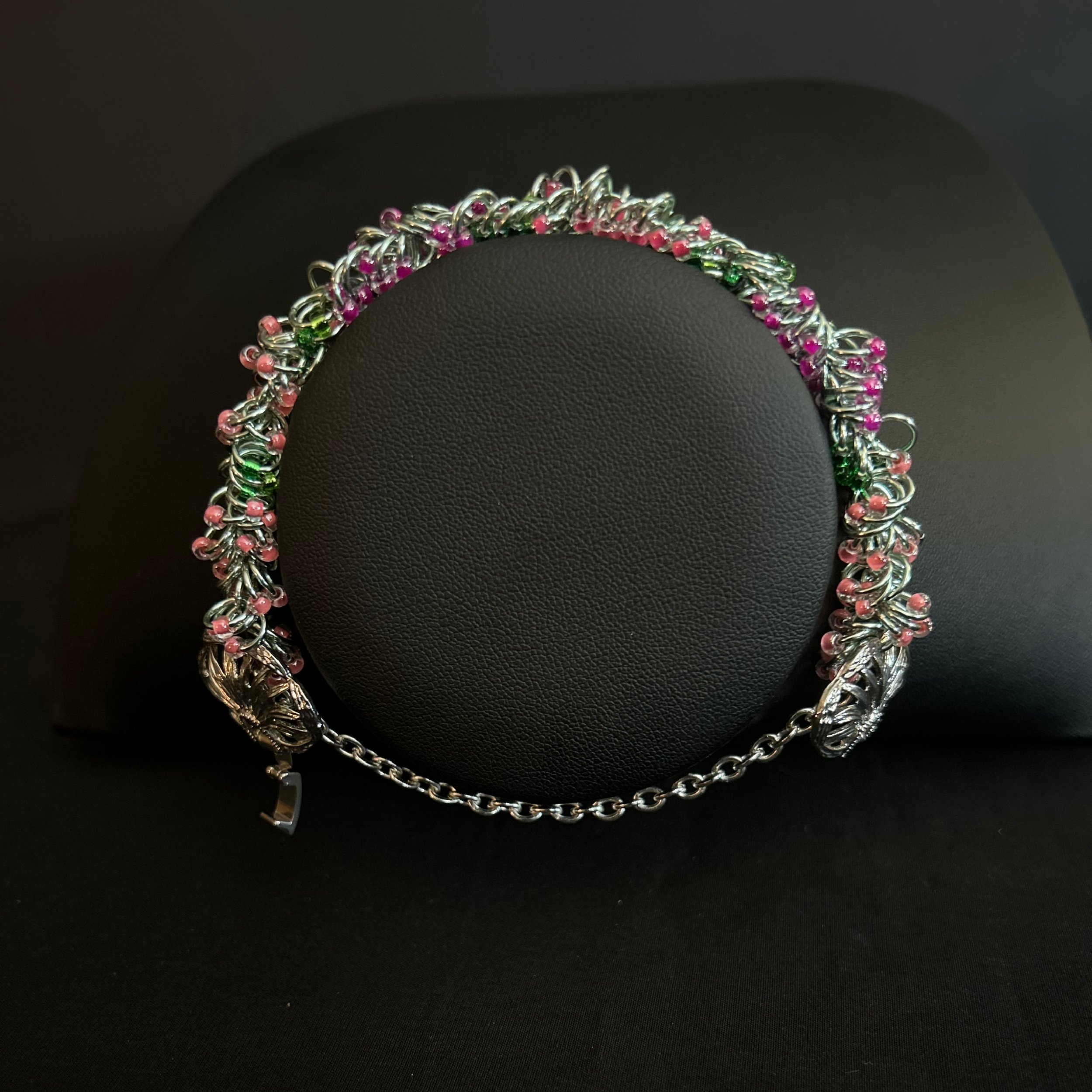 “Hello Springtime bracelet displayed on a black jewelry bust showing pastel spring colors.”