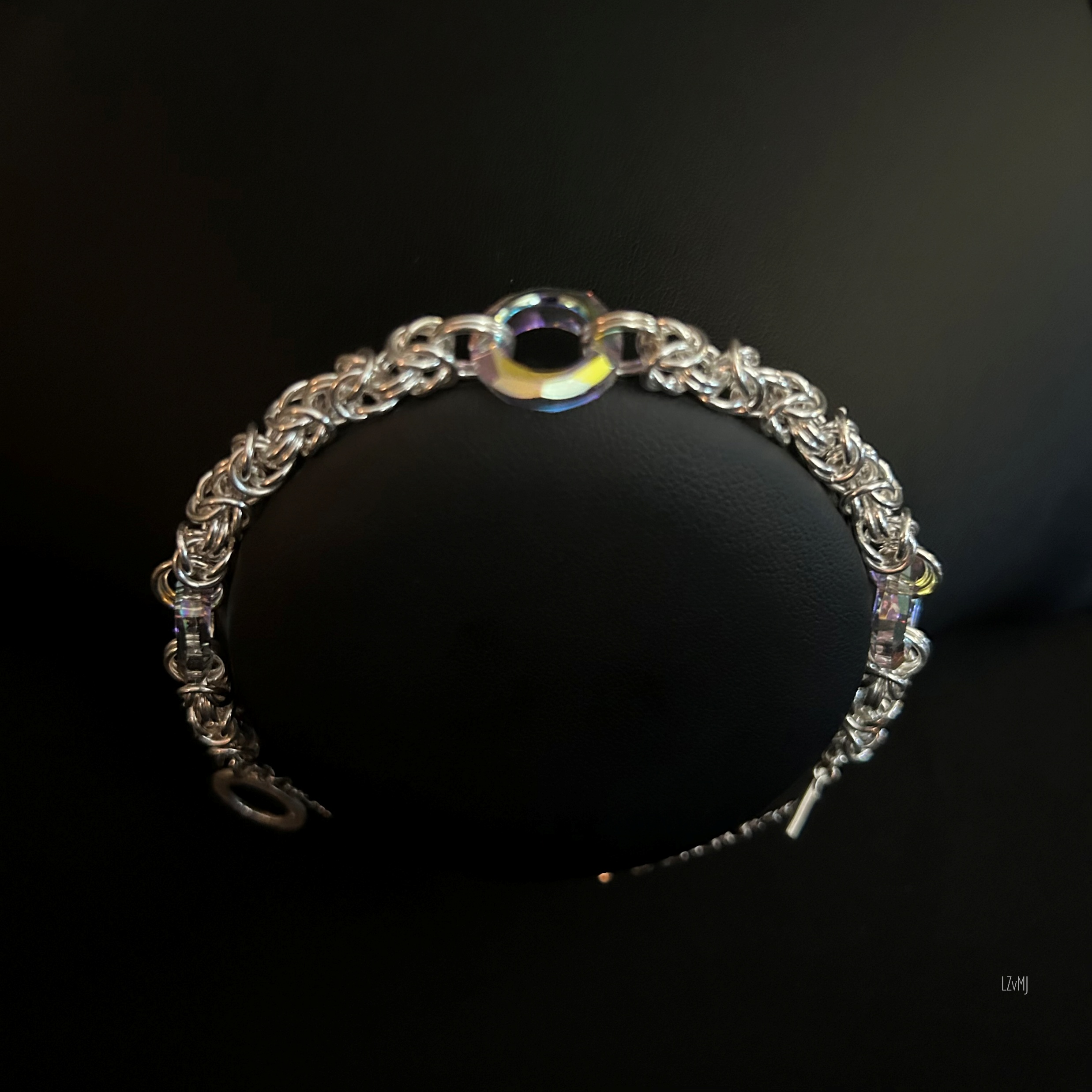 Sterling Byzantine chainmaille bracelet with iridescent Swarovski donuts displayed on a jewelry bust for scale and shine.
