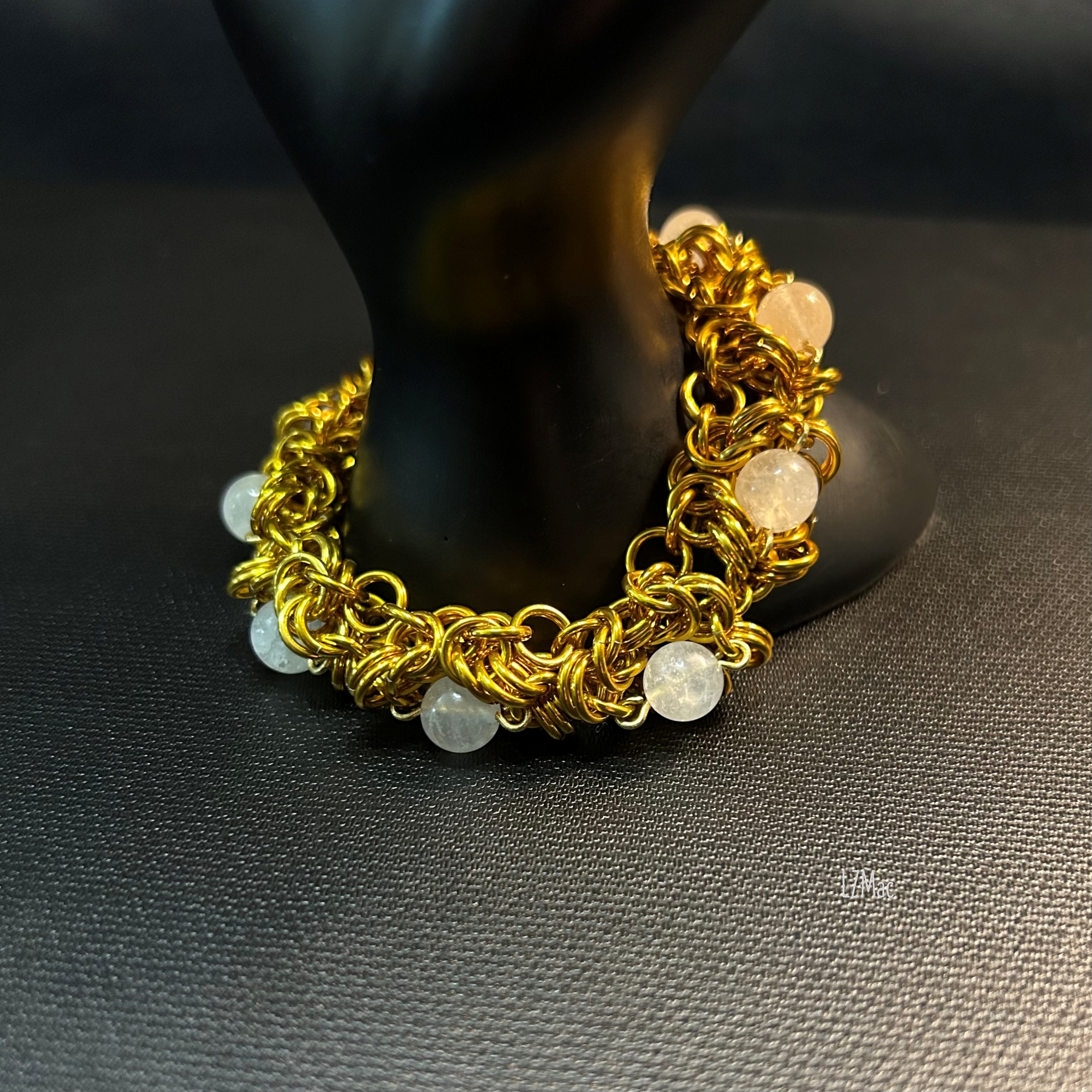 Moonlit Rosette Bracelet styled on a prop, highlighting the gold Byzantine rosettes and glowing moonstone beads.