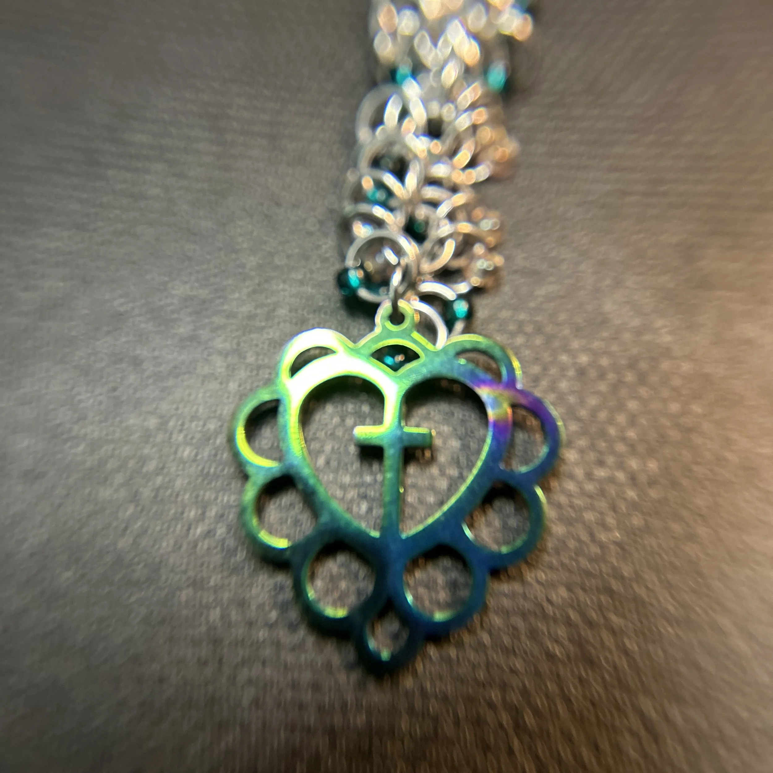 “Silver ring purse charm with green accent beads and iridescent heart‑and‑cross focal, 5.5 inches long with swivel clasp.”