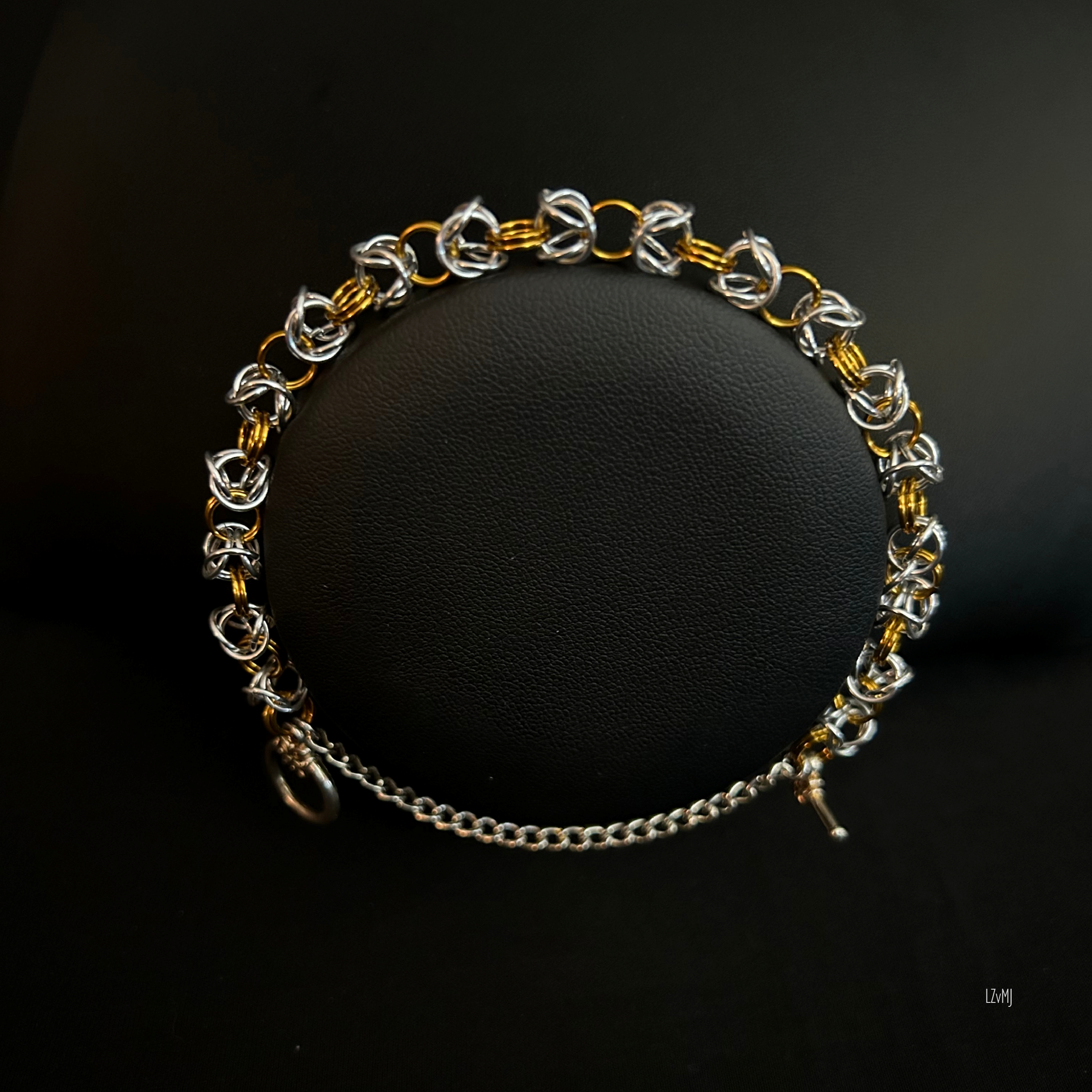 “Silvergold Byzantine bracelet displayed on a black jewelry bust showing the mixed‑metal pattern.”
