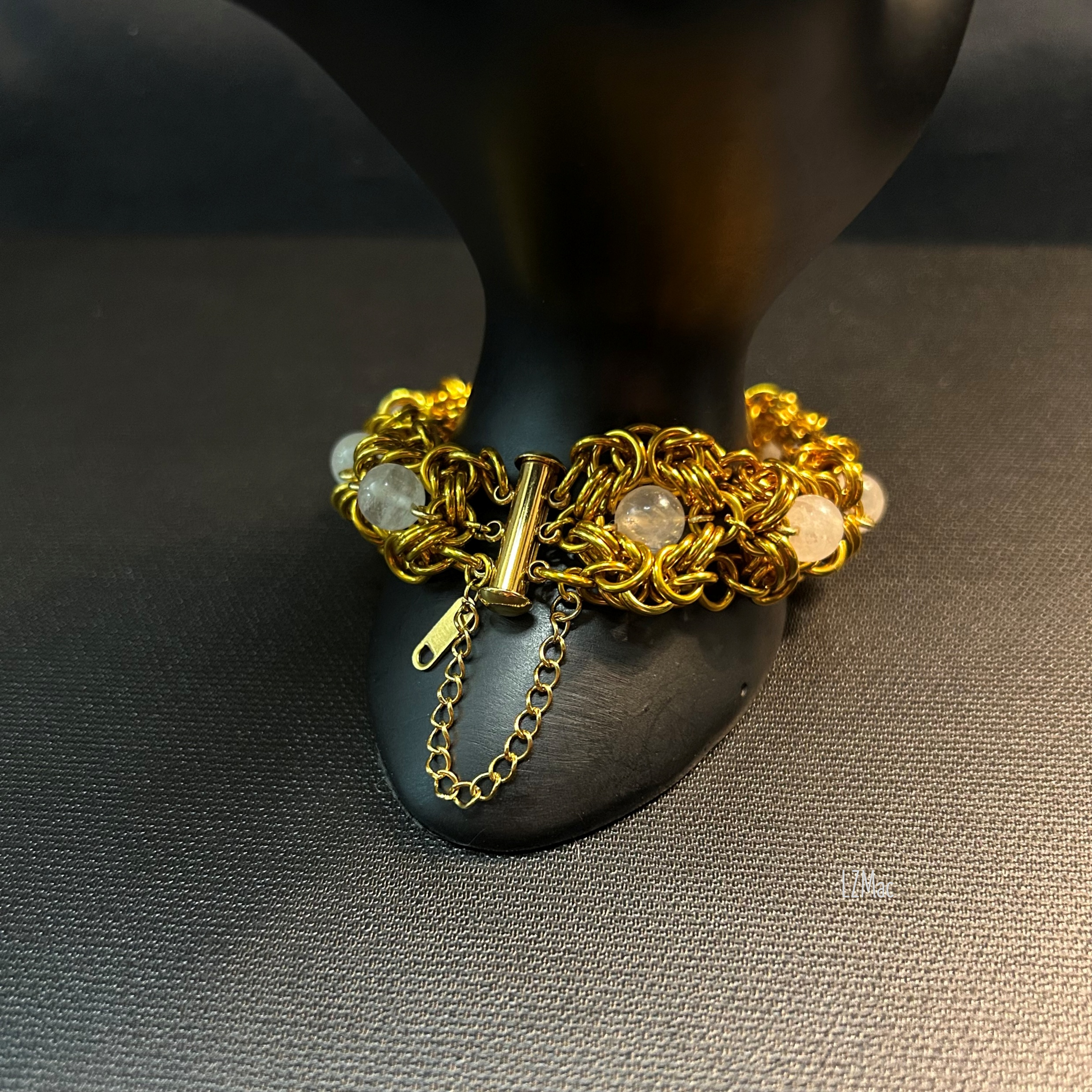Moonlit Rosette Bracelet styled on a prop with a close view of the stainless slide‑lock clasp and safety chain.