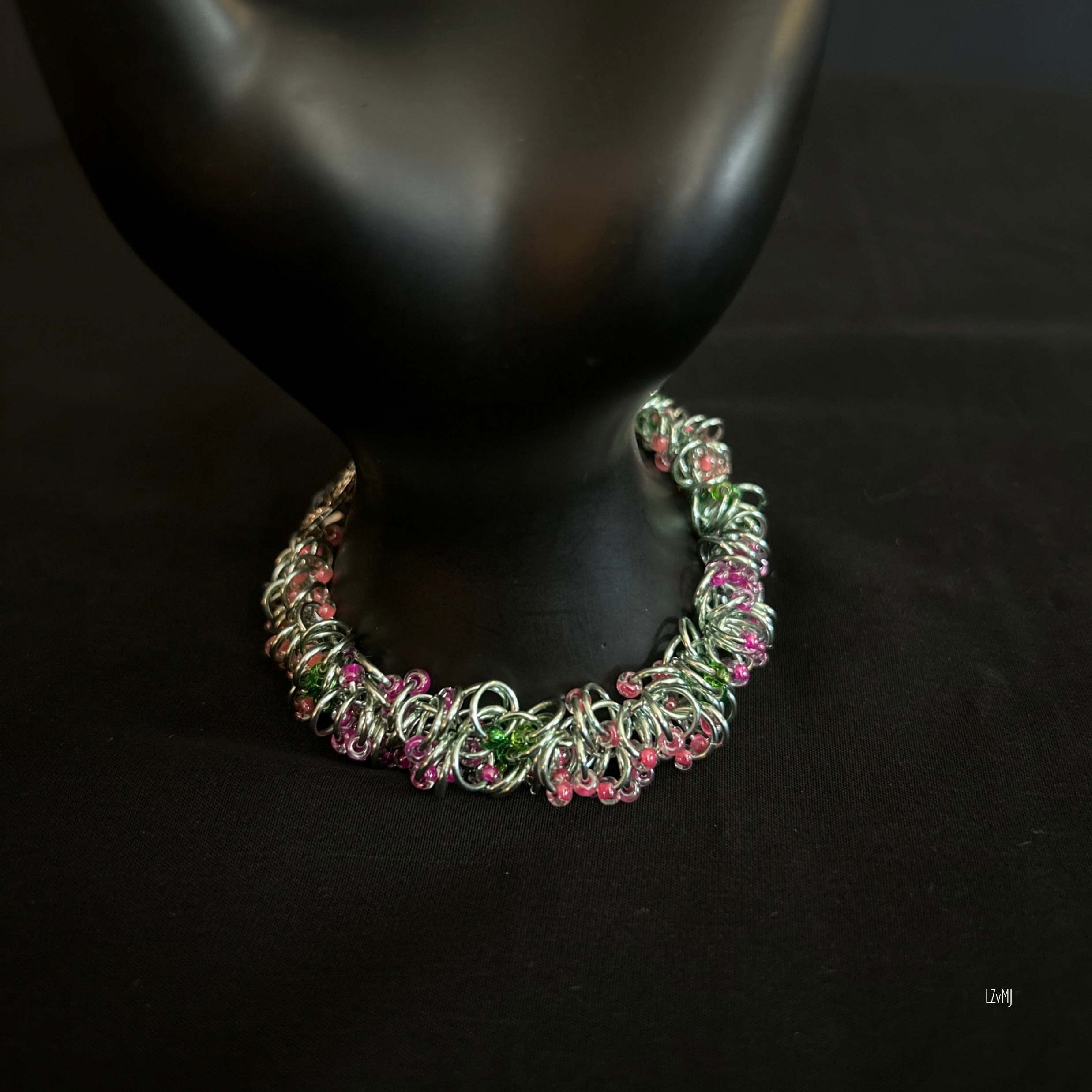 “Hello Springtime bracelet with pastel beads and silver rings displayed on a prop.”
