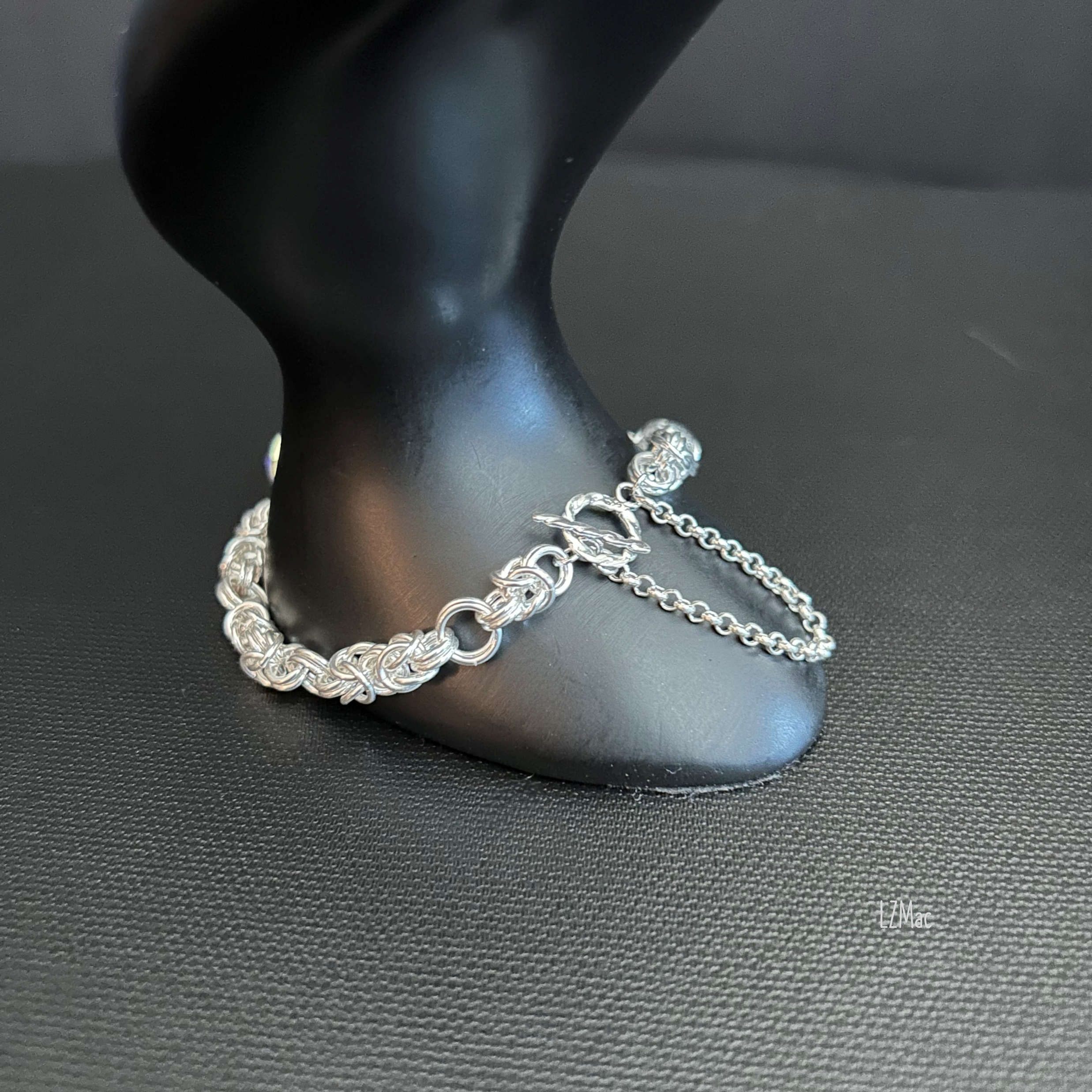 Sterling toggle clasp and safety chain of the Silver Halo bracelet displayed on a prop for detail.