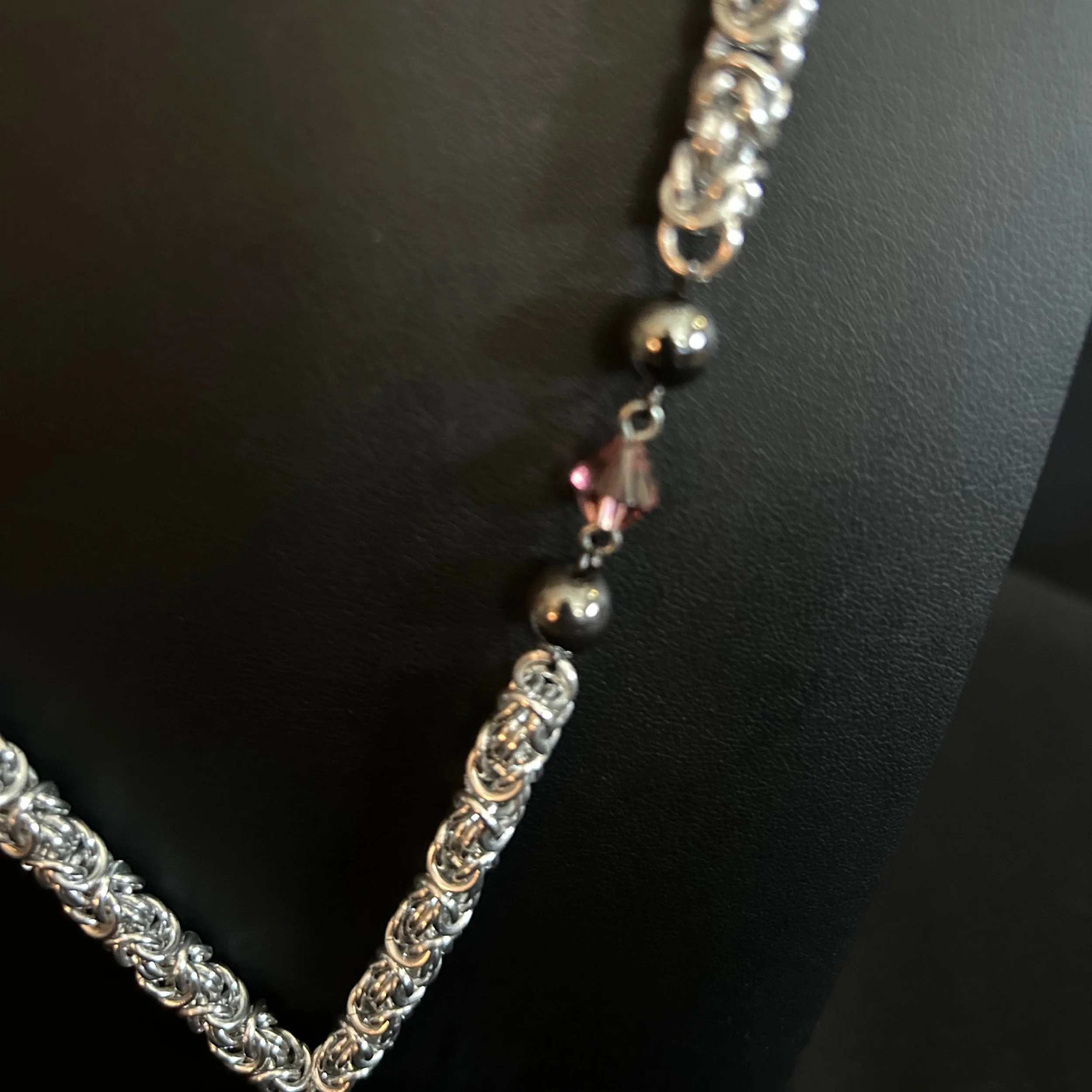 “Detail of the aluminum Byzantine weave with hematite and plum glass bead accents.”