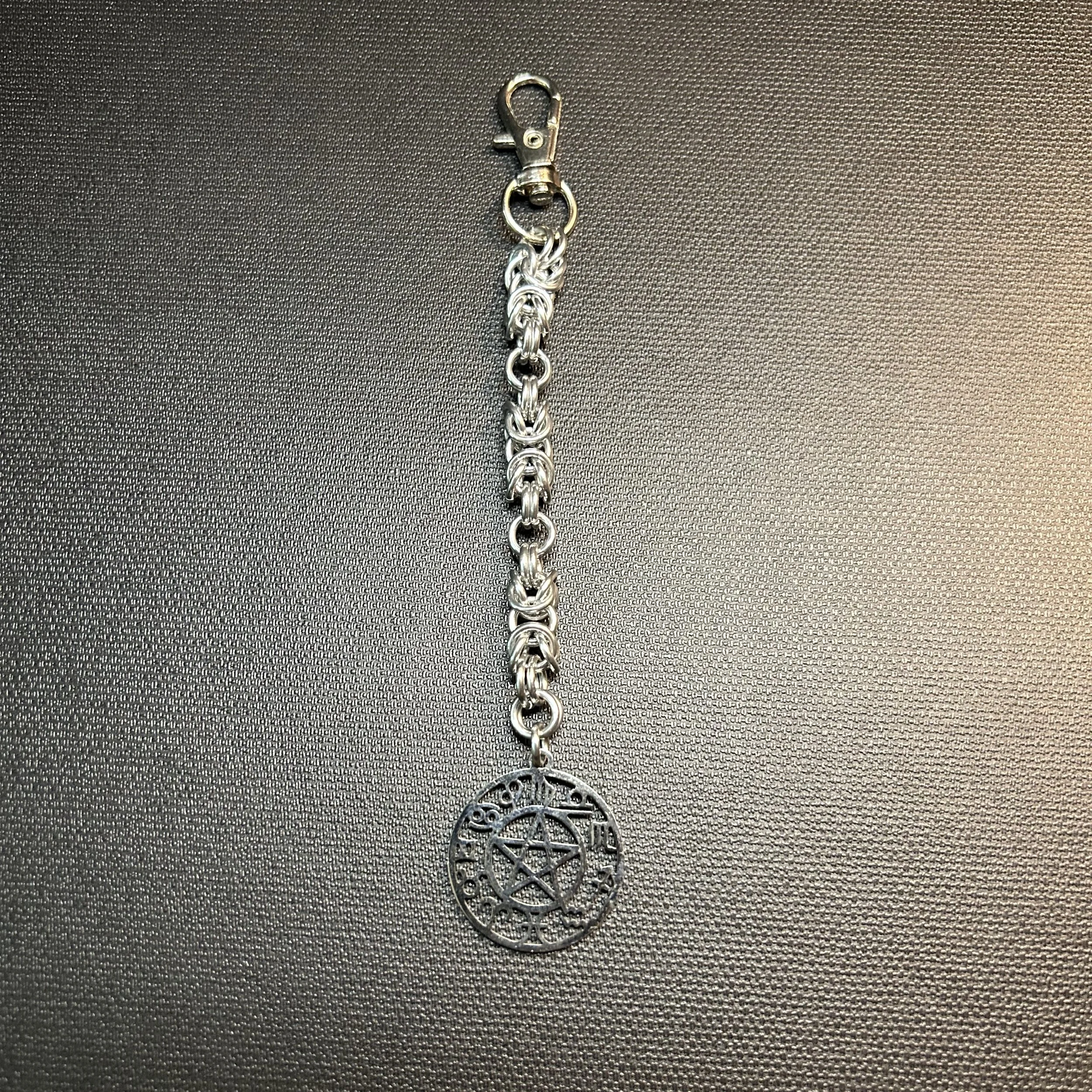 “Silver Byzantine purse charm with 1-inch round Zodiac focal, 5.5 inches long with swivel clasp.”