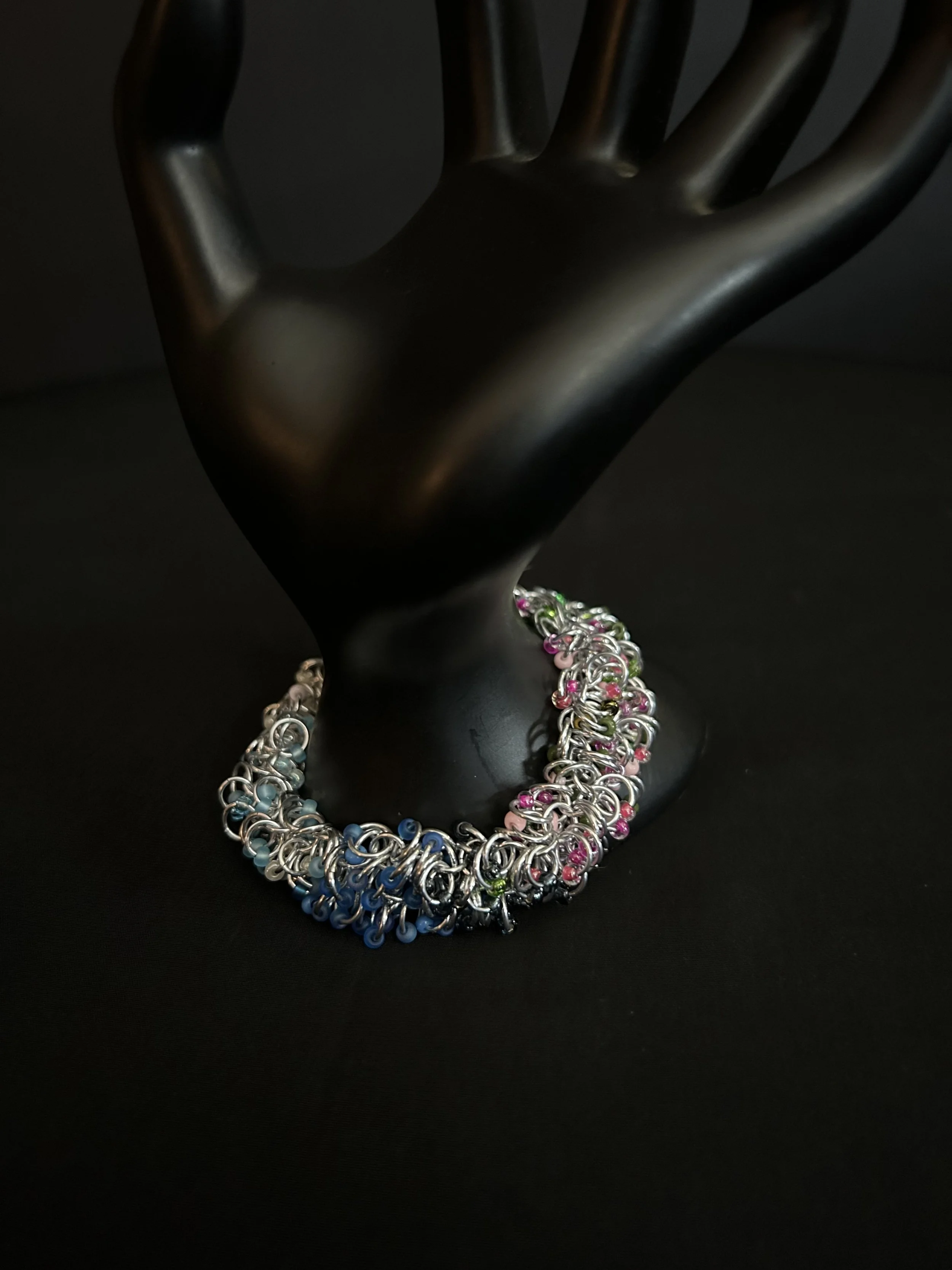 Blue Ridge Spring Bracelet draped over a dark display prop showing its spring-inspired colors.