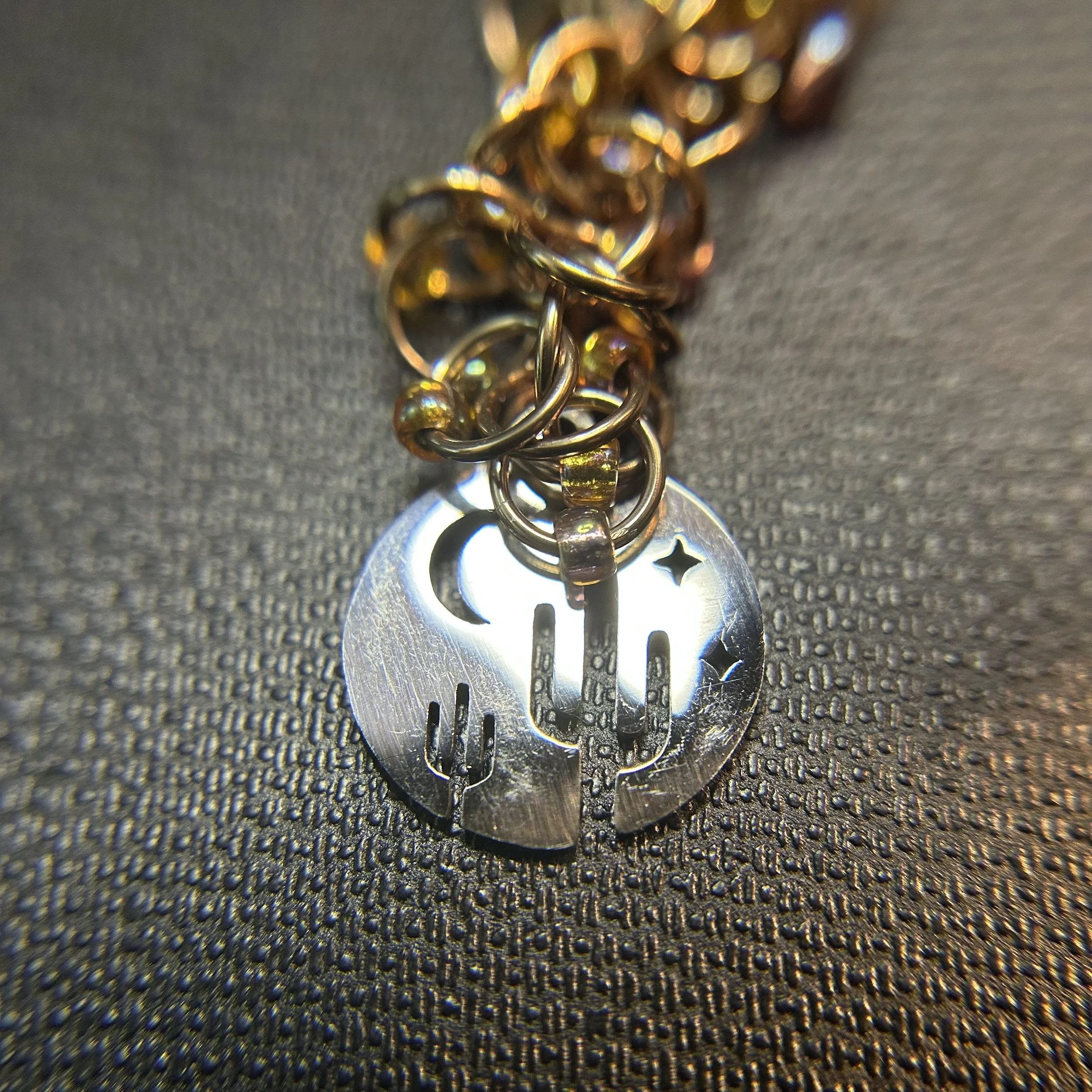 “Desert Night purse charm with champagne rings, gold accent beads, and swivel clasp, 5.25 inches long.”