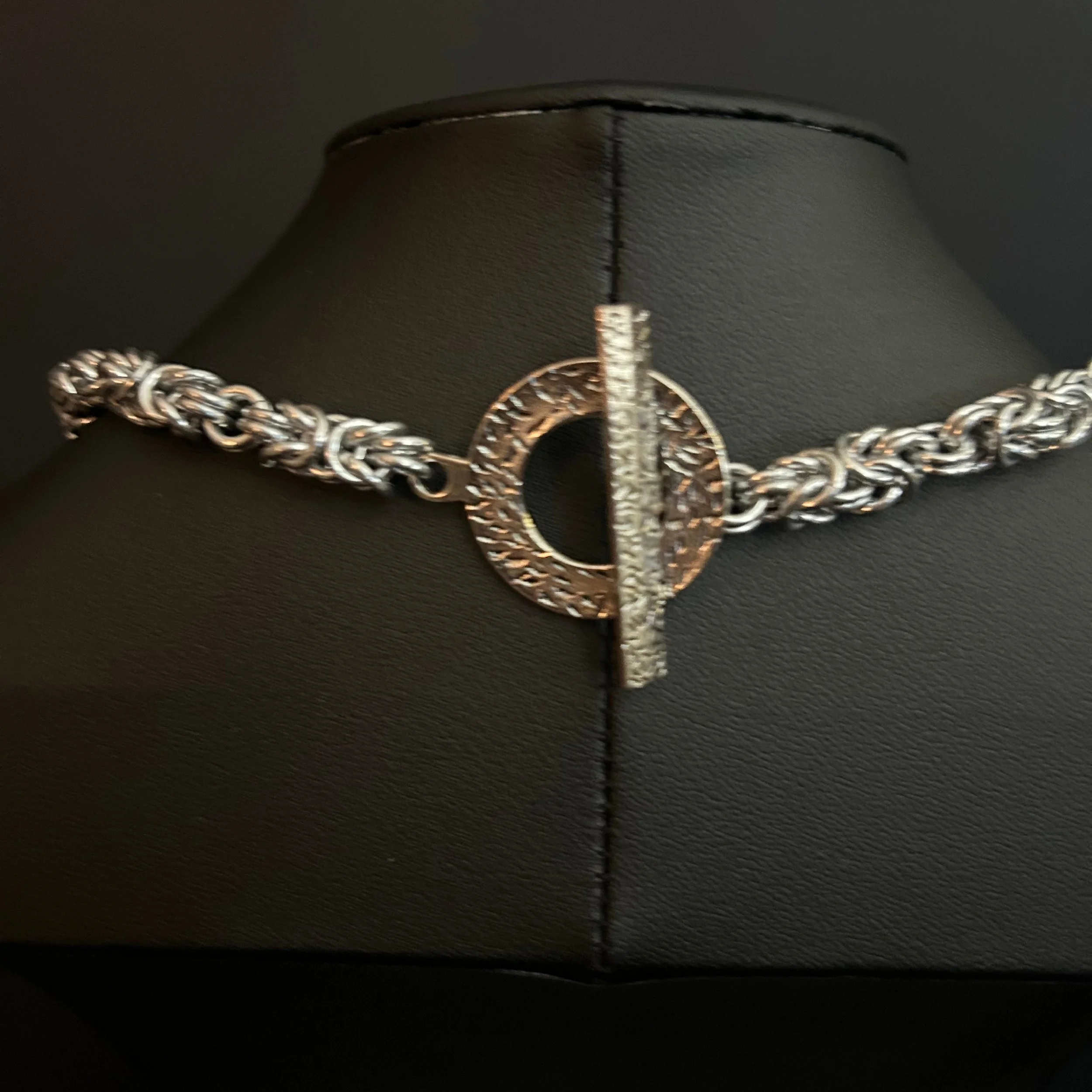 “Close-up of the silver toggle clasp and connecting aluminum rings.”