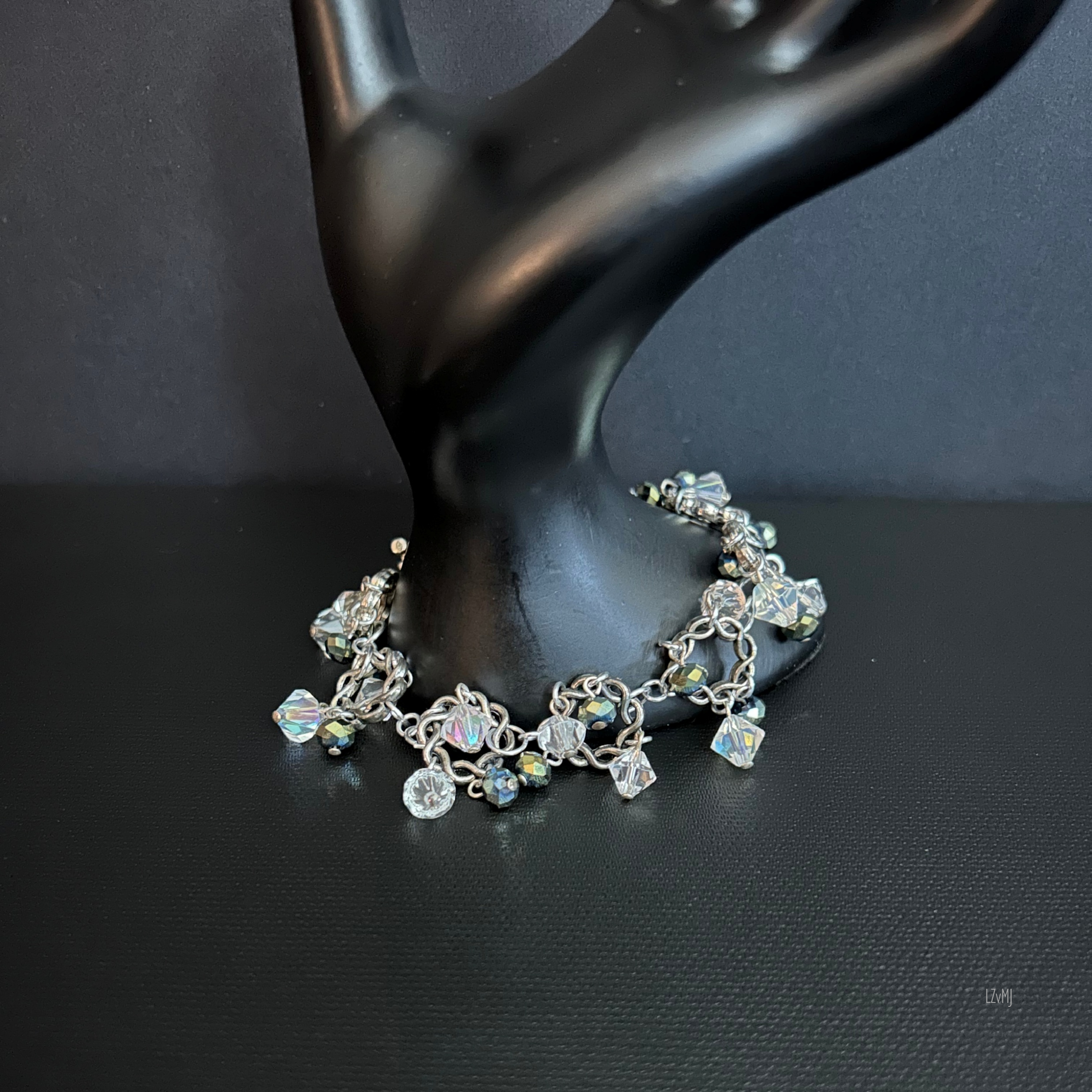 Bracelet draped over a prop, showing the twisted silver circles and shimmering crystal clusters
