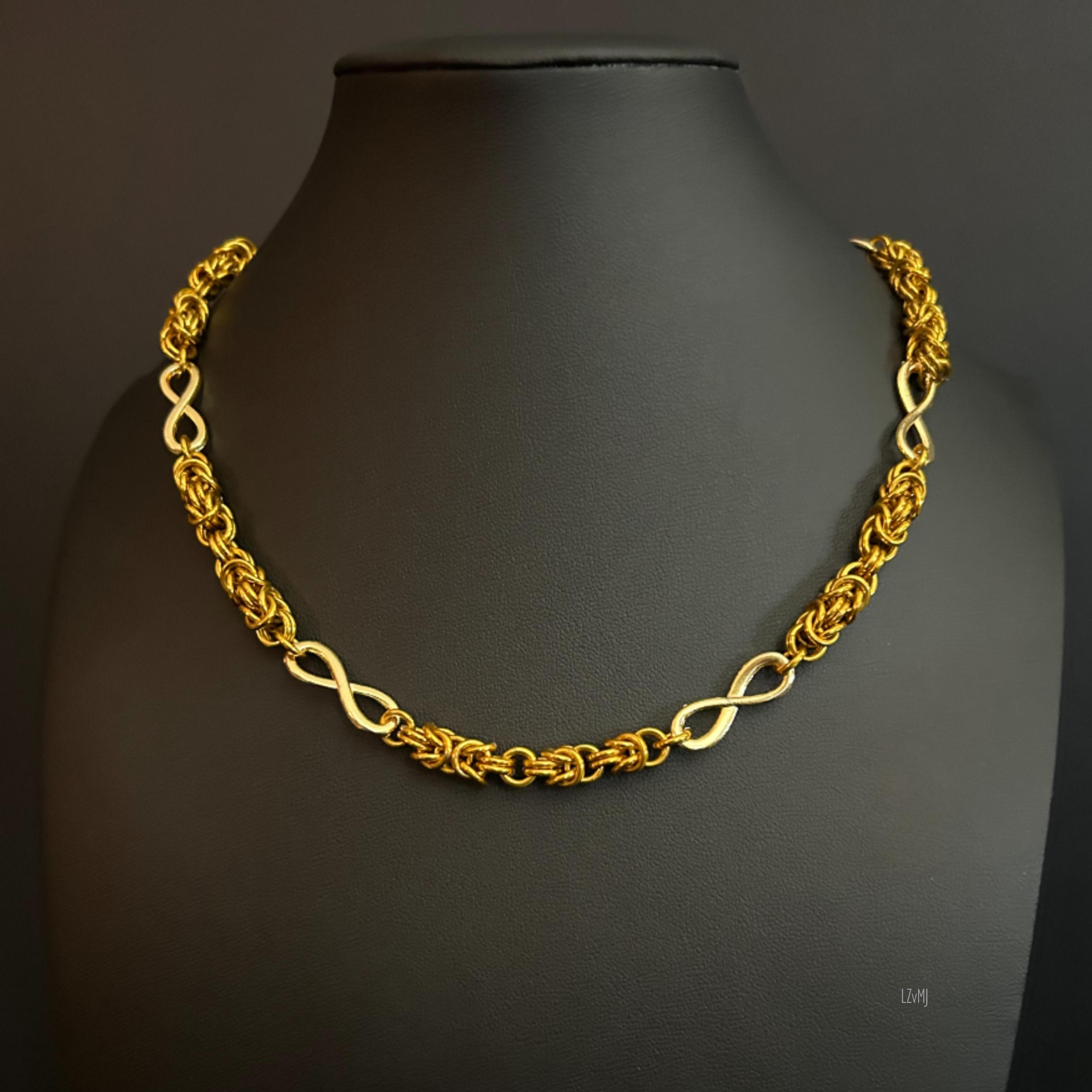 Golden Infinity necklace displayed on a black bust, featuring alternating Byzantine chainmaille segments and gold infinity connectors