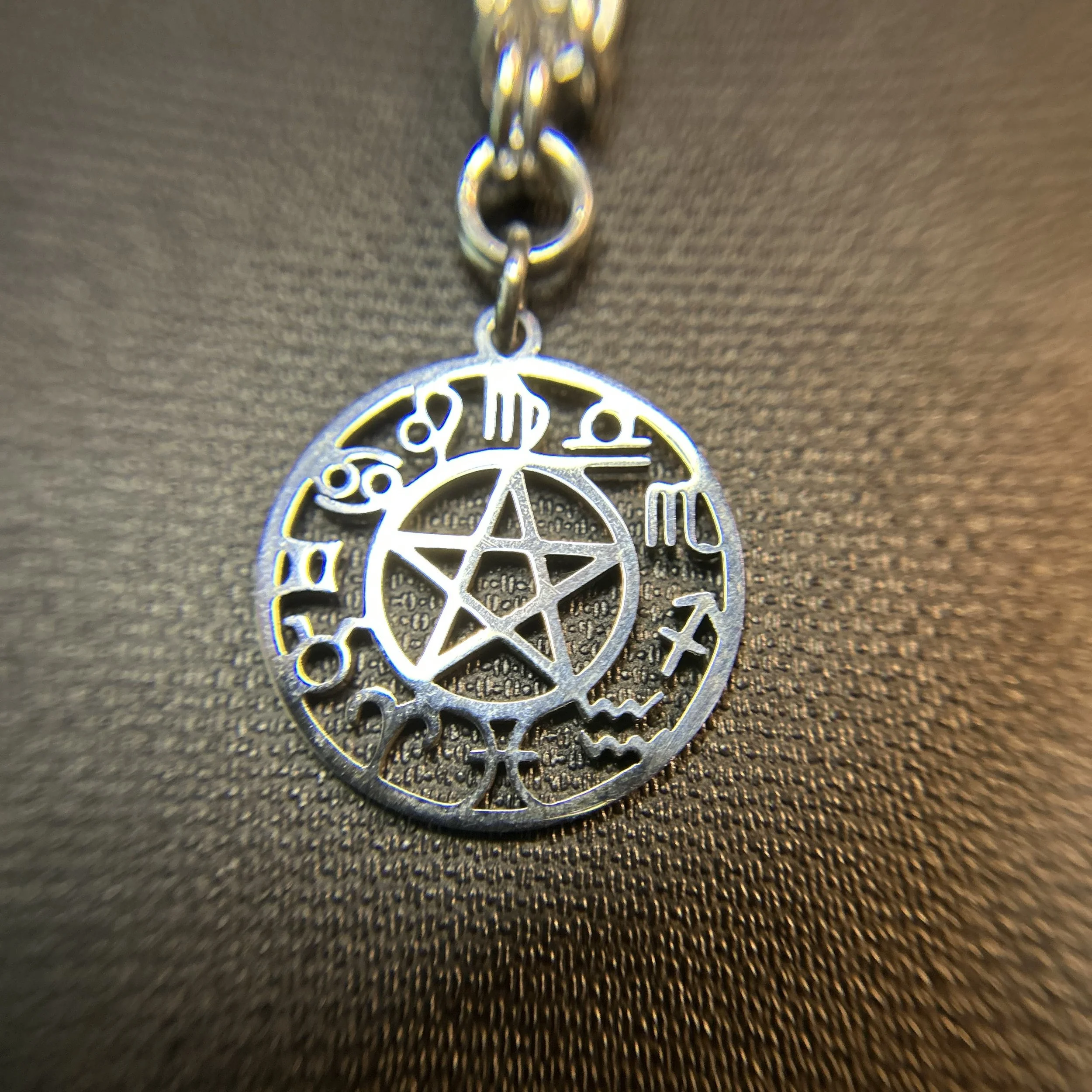 “Close-up of 1-inch round silver Zodiac focal on Byzantine chainmaille purse charm.”