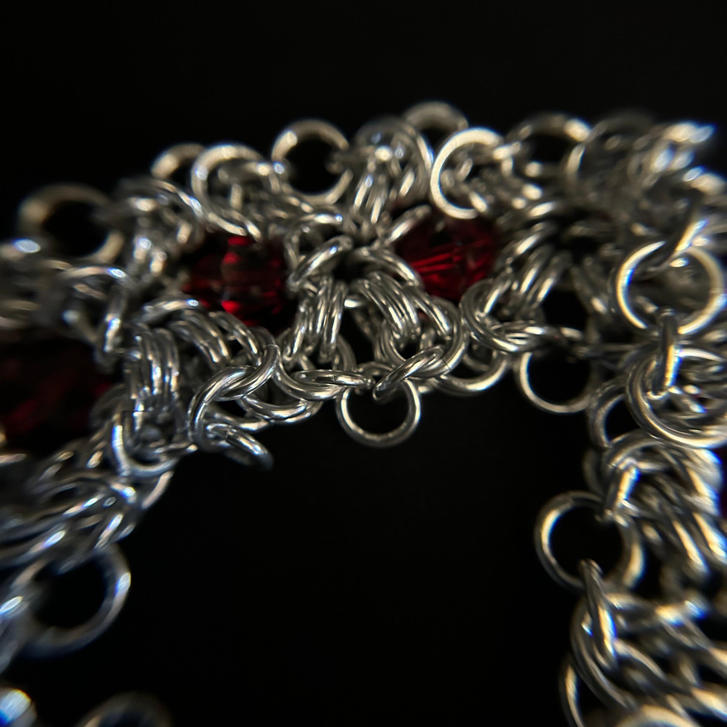 Closeup of Ruby Frost silver Byzantine rosette weave with red glass crystals