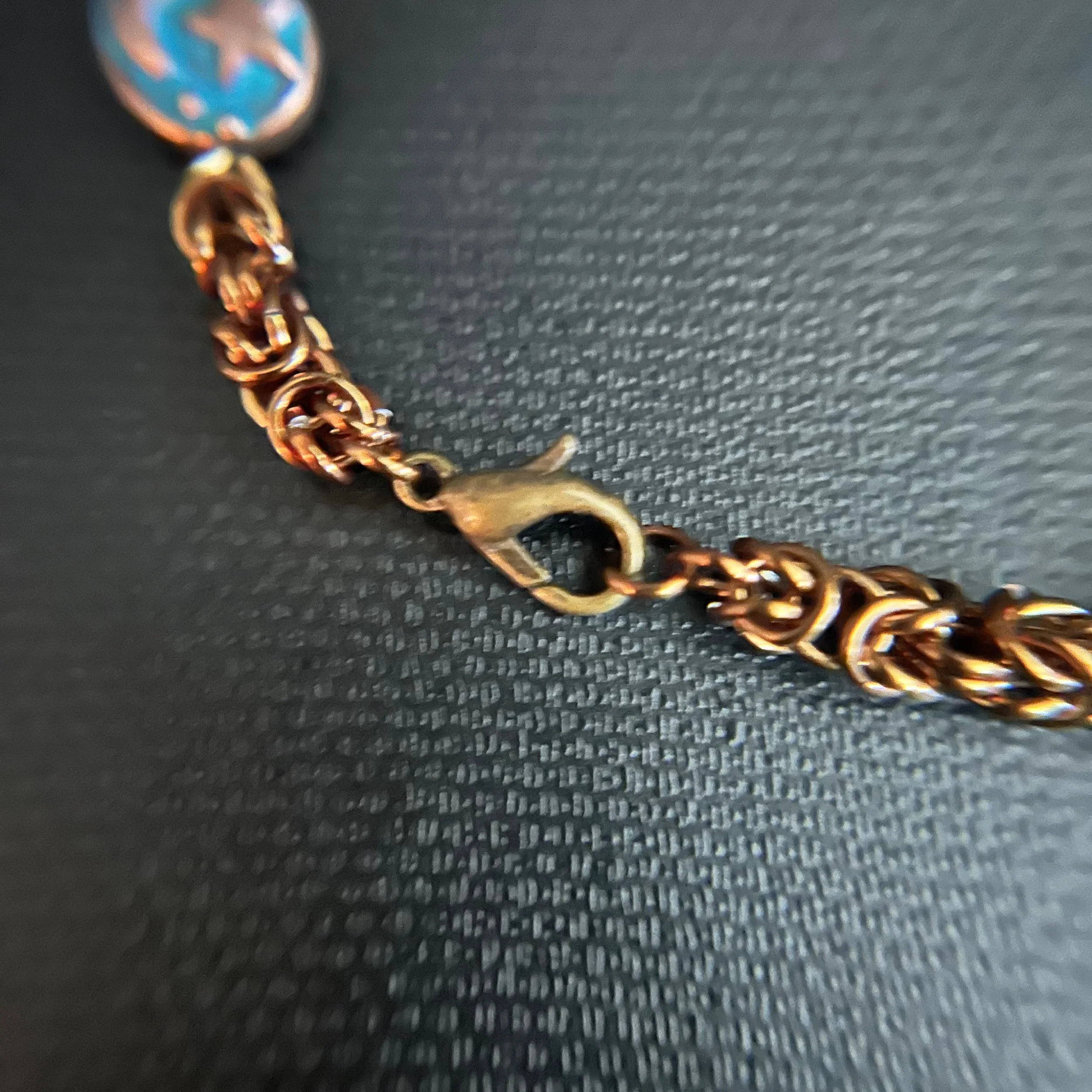 Close-up of the lobster clasp and bronze chain links