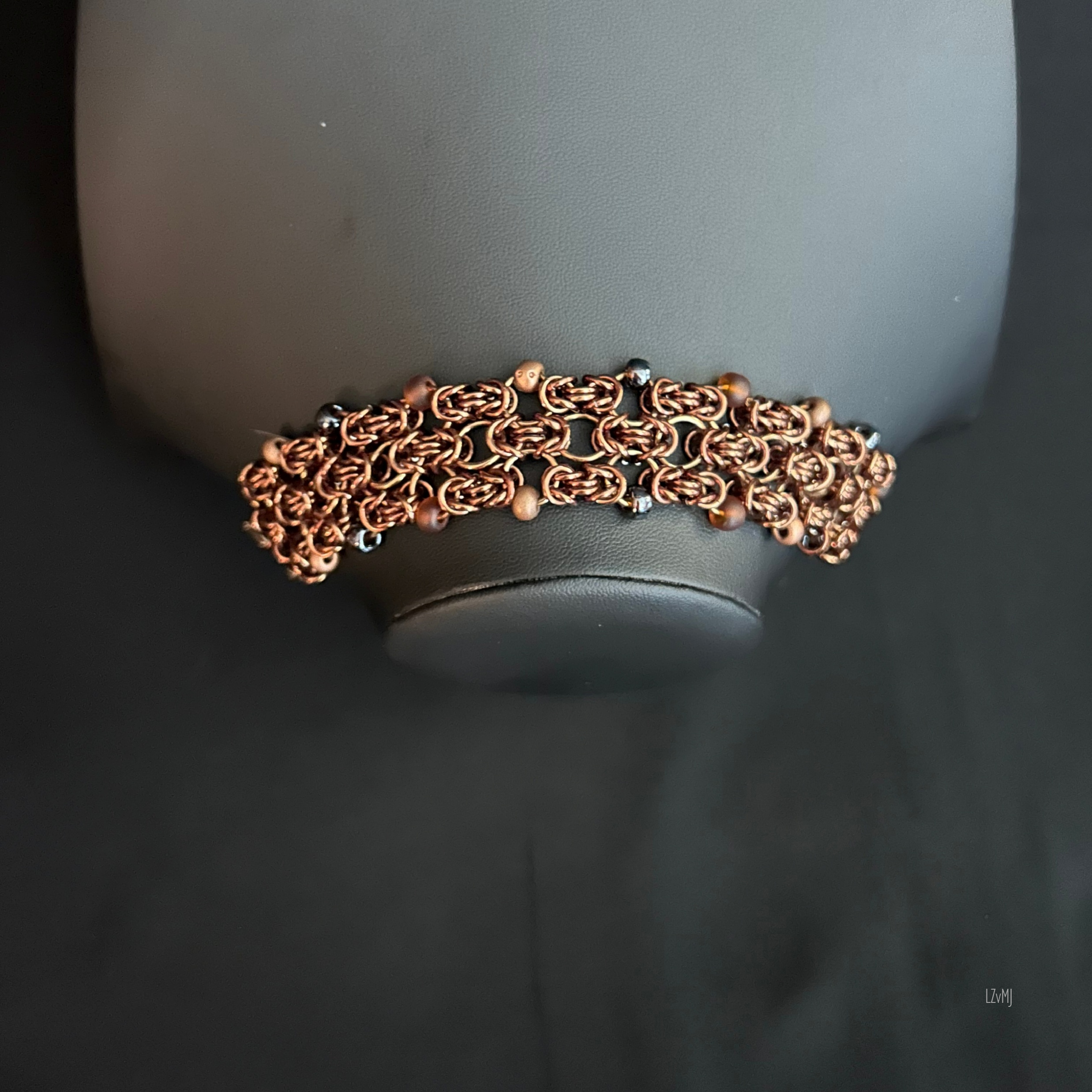 “Bronze Ember bracelet displayed on a black jewelry bust showing the warm bronze tones.”