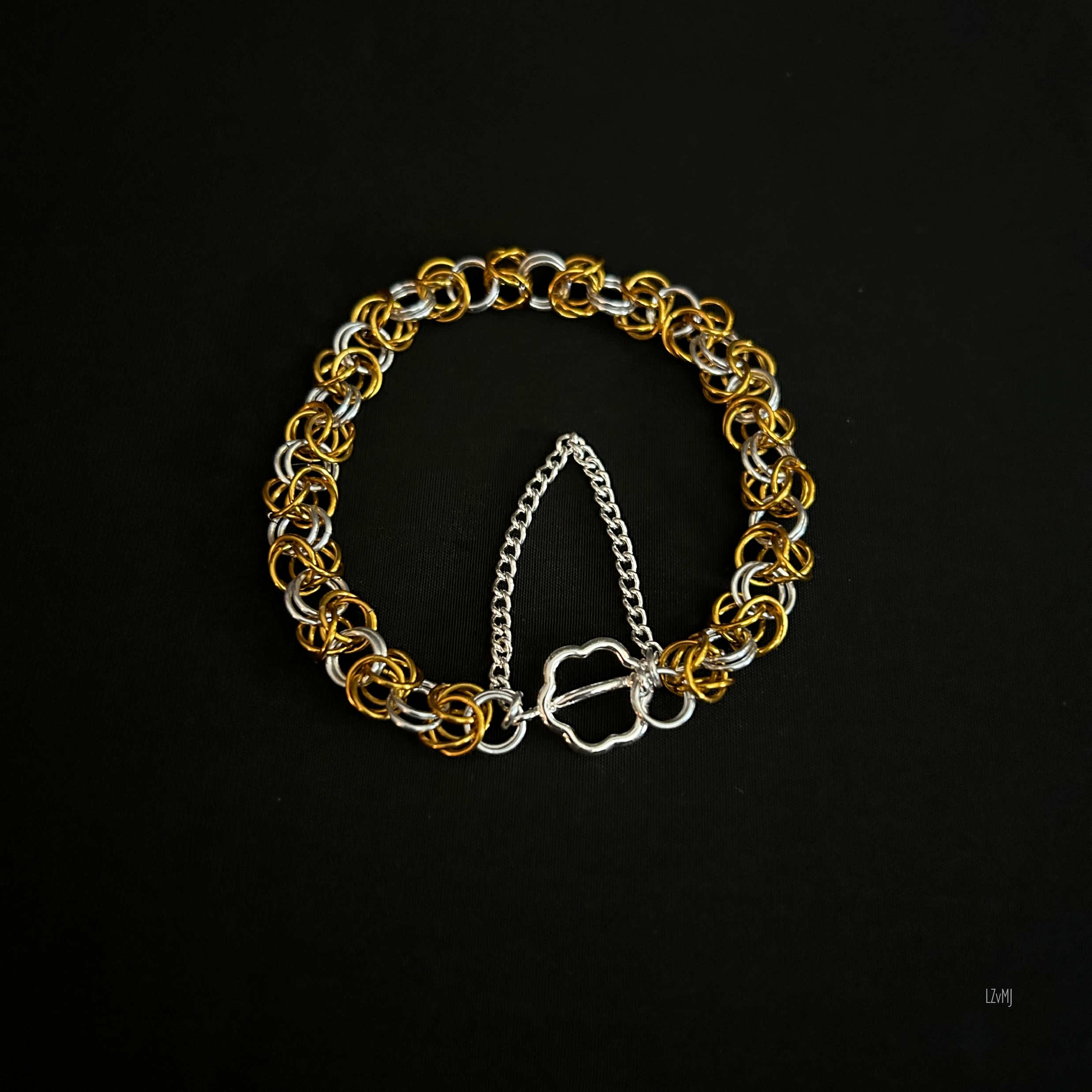 “Goldsilver Byzantine bracelet laid flat in a round shape showing the two‑tone rings.”