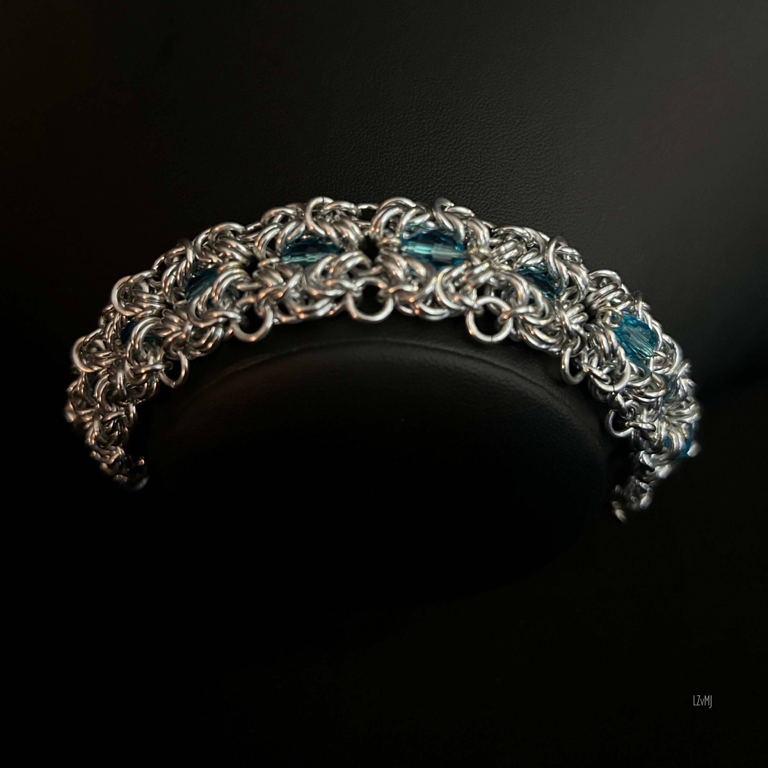 Close-up of the Turquoiseberry Byzantine bracelet showing the interwoven aluminum rings and vivid turquoise crystal inserts