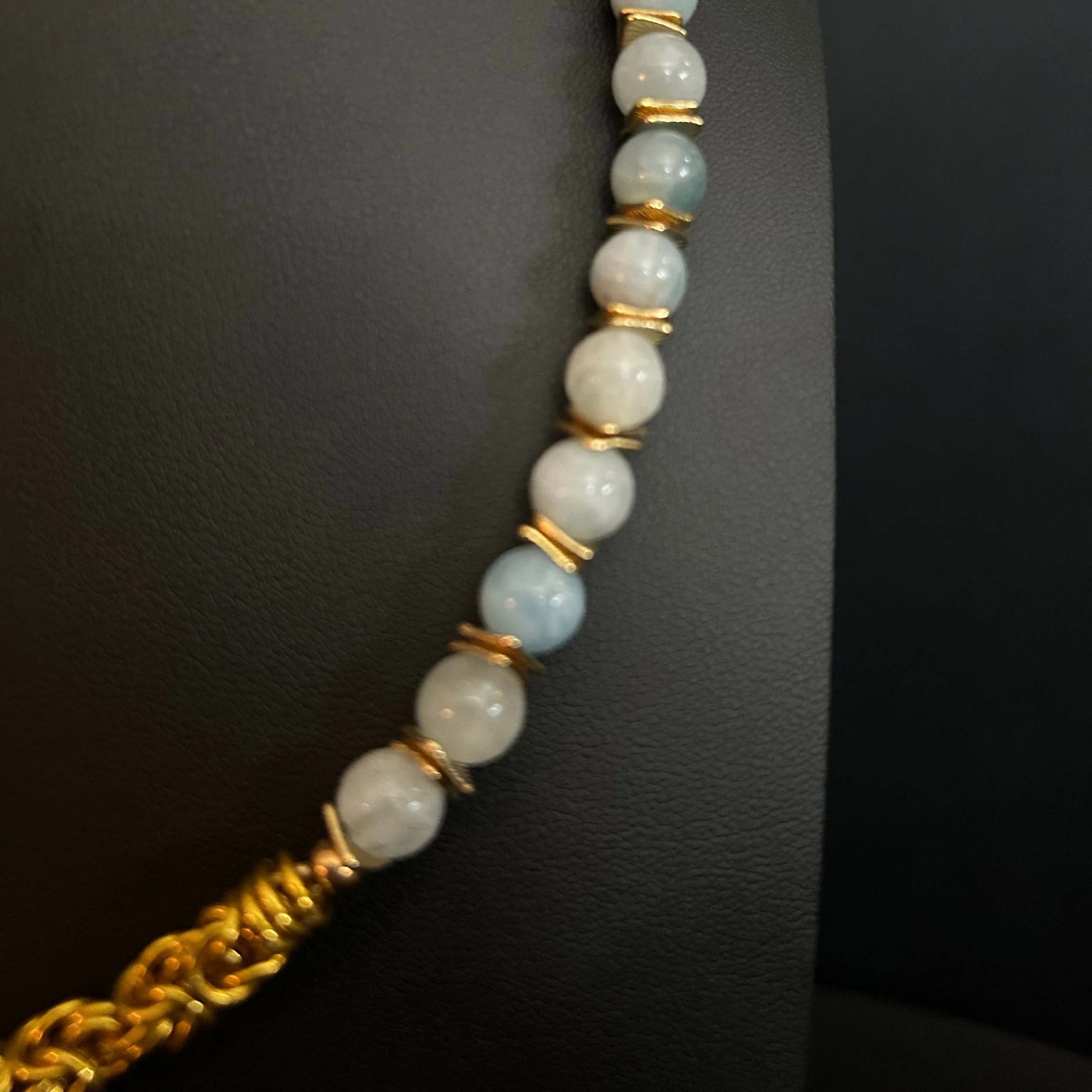 “Detail of the aquamarine beads with square gold‑tone spacer accents.”