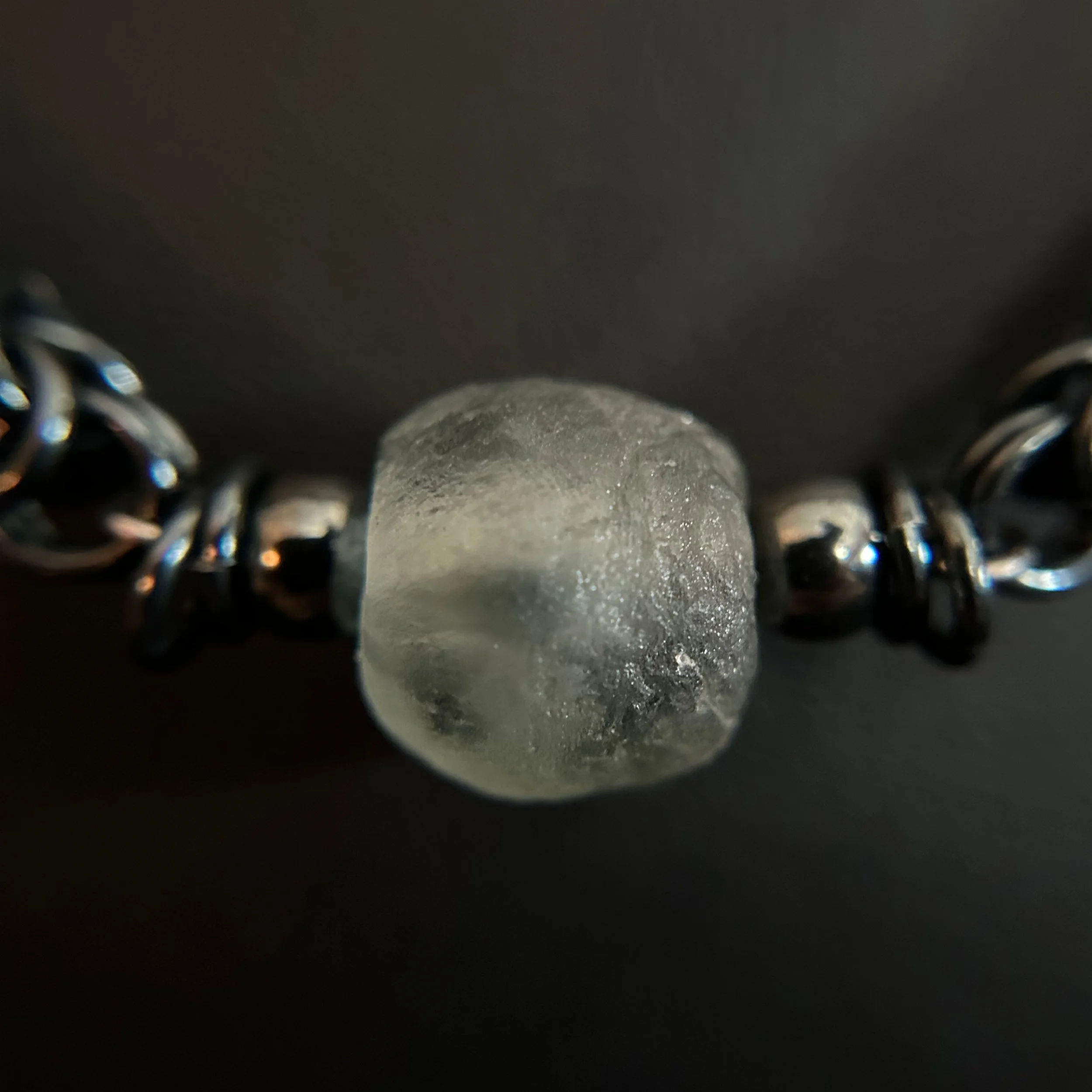 “Detail of the matte slate bead with silver spacers on the chain.”