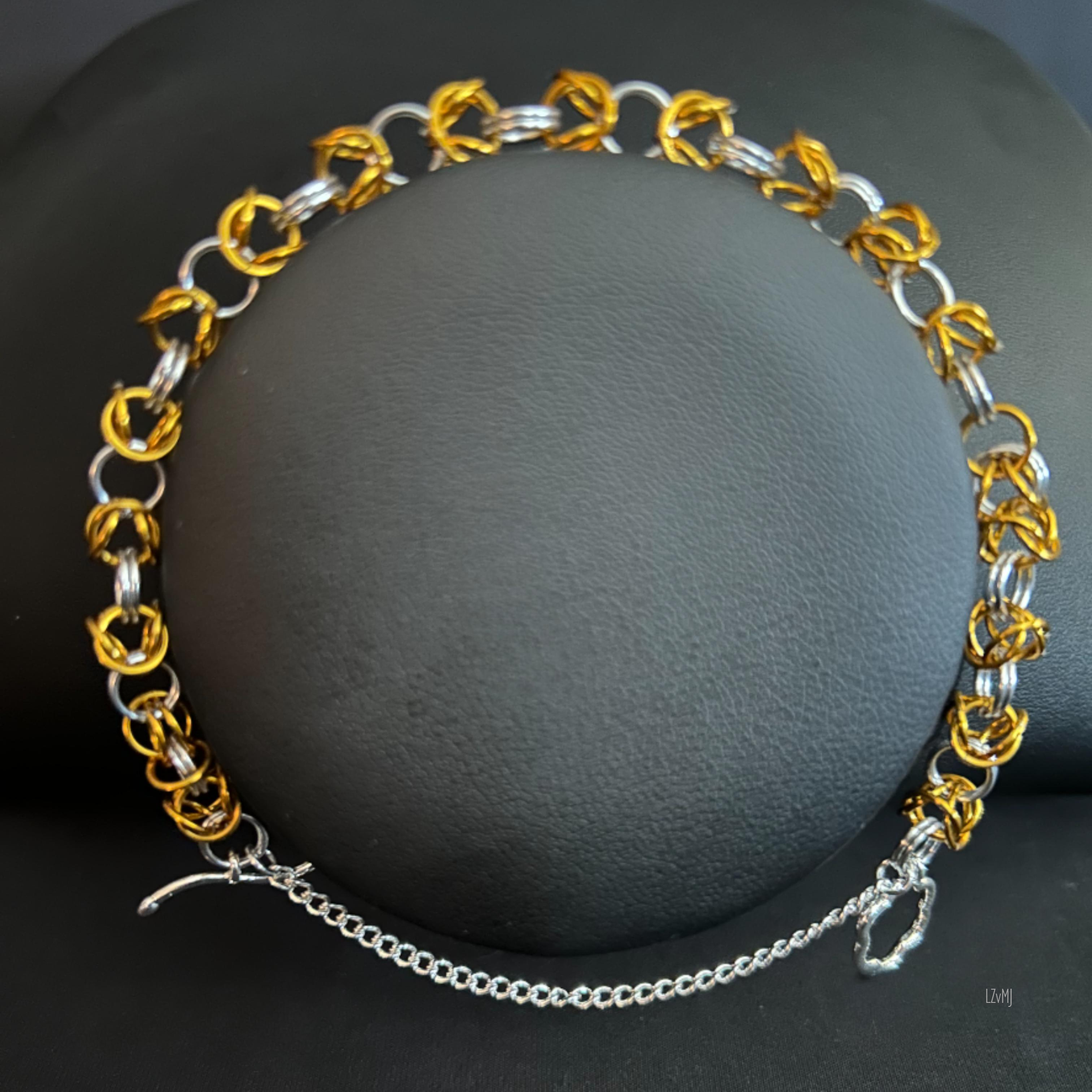 “Goldsilver Byzantine bracelet displayed on a black jewelry bust showing the gold and silver pattern.”