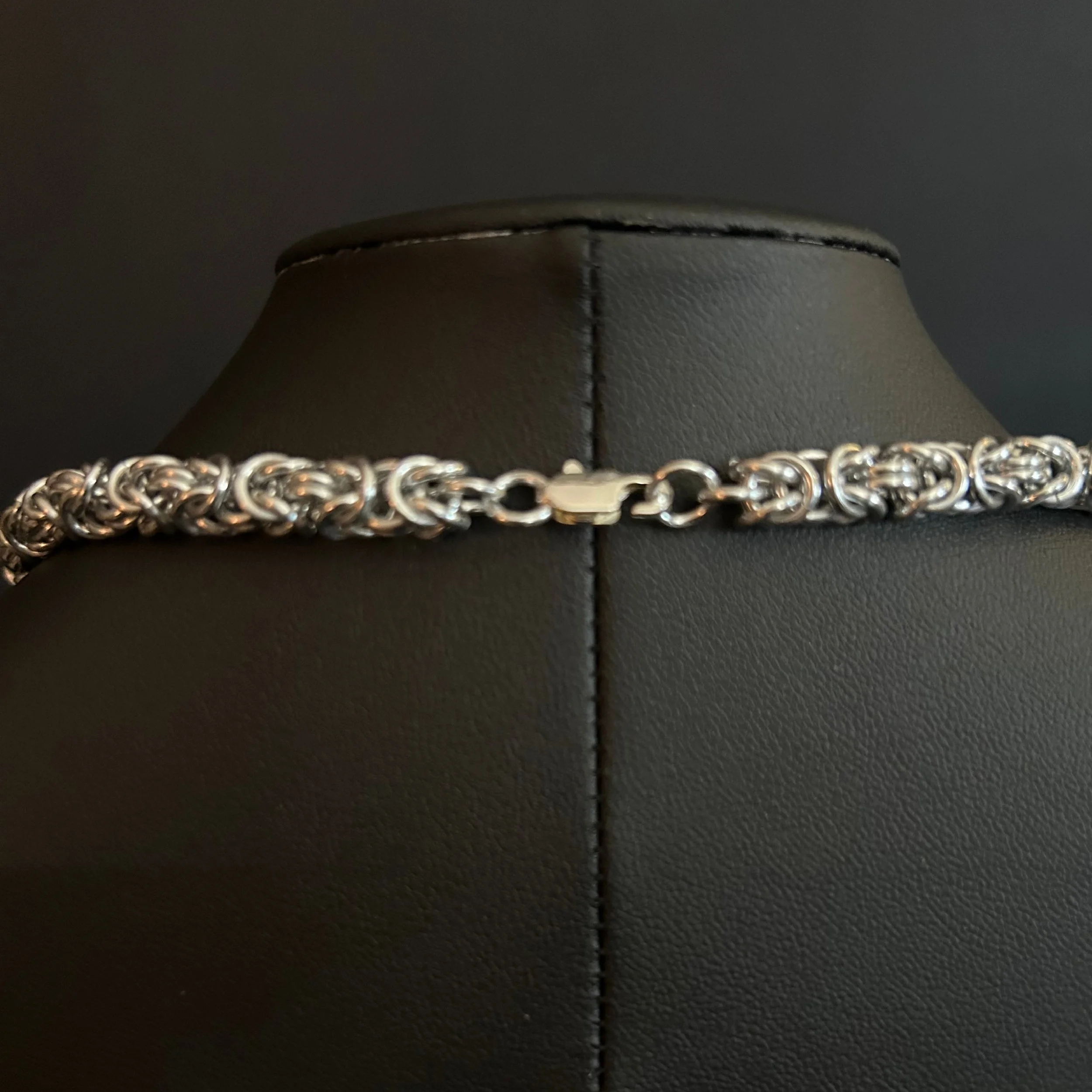 “Close-up of the silver-plated lobster clasp and connecting aluminum rings.”