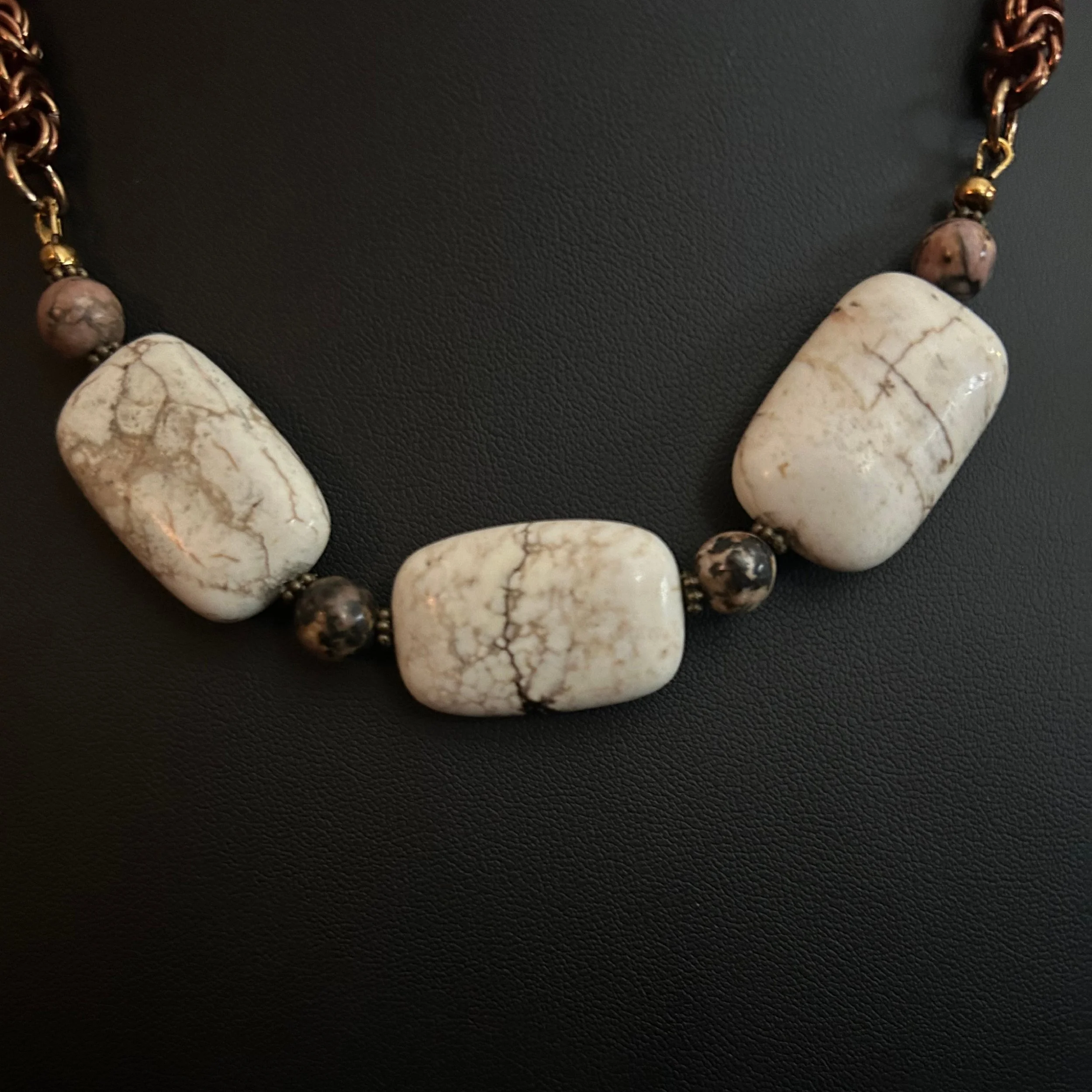 “Close-up of the magnesite stones with natural veining and rhodonite bead accents.”