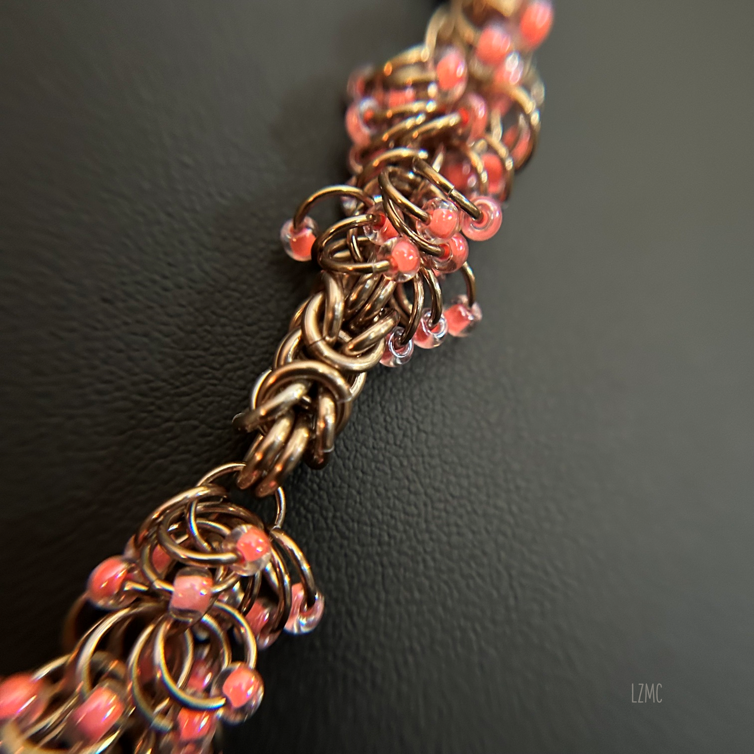 Detail shot of the champagne‑tone shaggy loop weave with soft pink 8/0 Miyuki beads, showing the layered texture and handwoven construction.