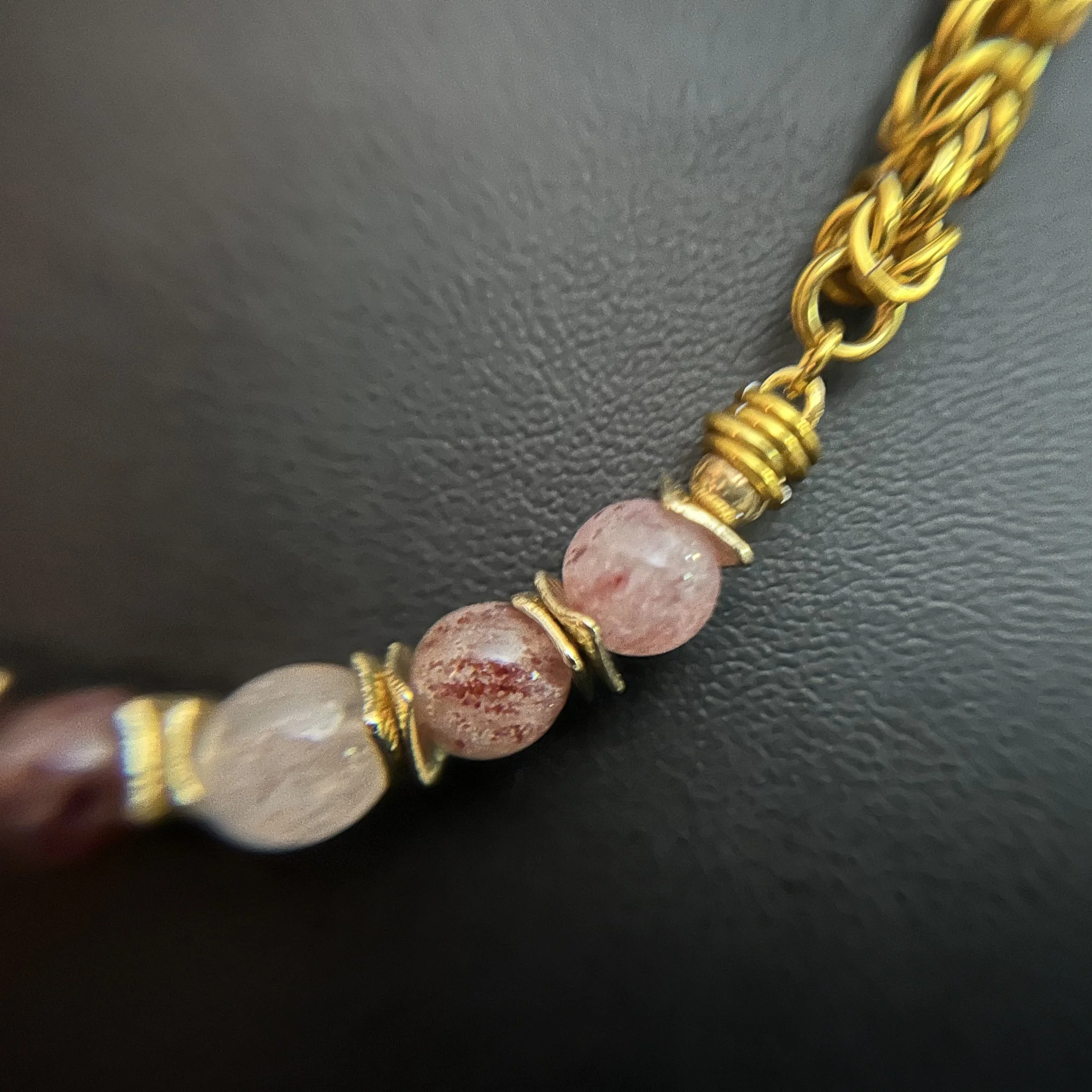 “Close-up of the strawberry quartz stones with gold‑plated spacer accents.”