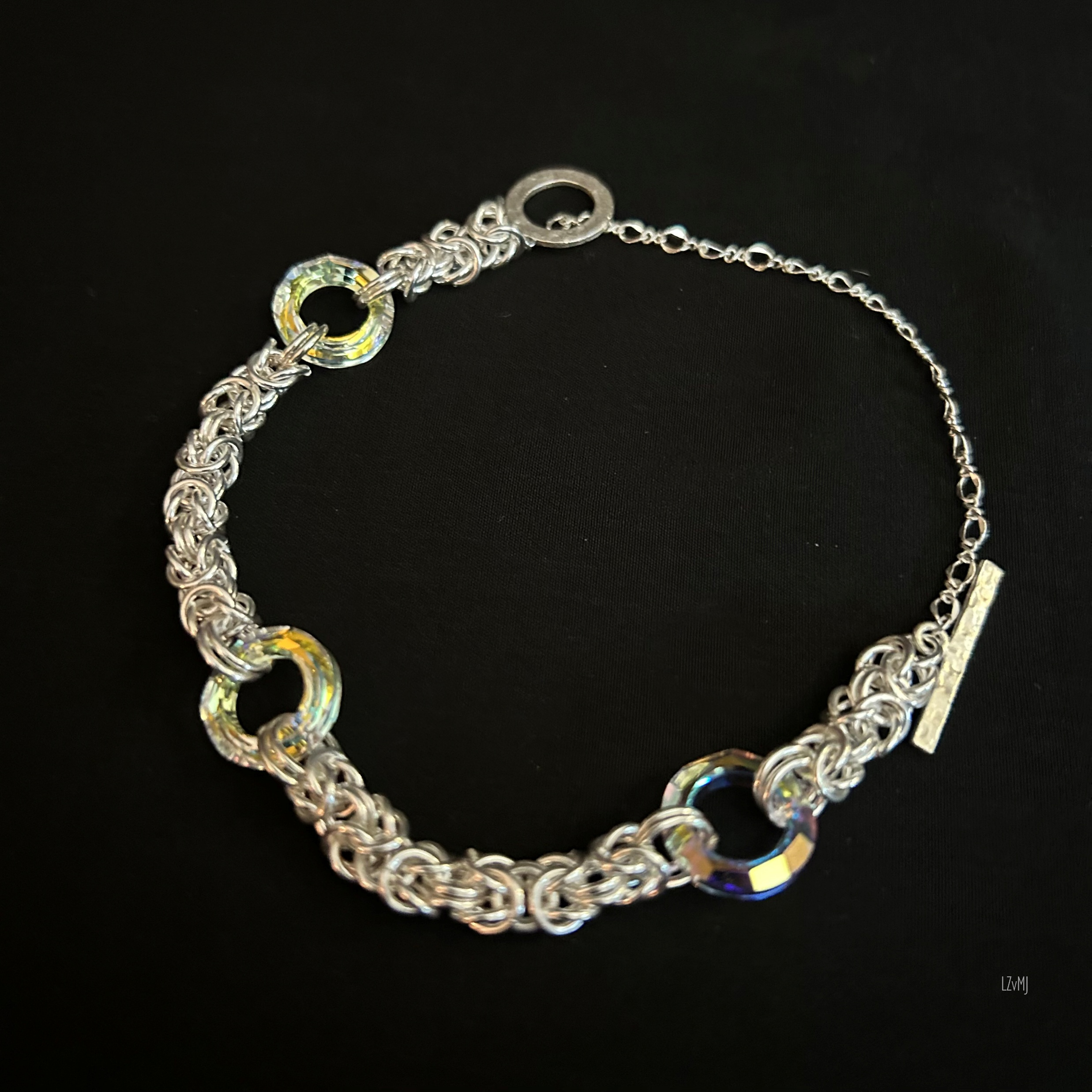 Open flat view of a .925 Sterling Byzantine bracelet featuring iridescent 14mm Swarovski donuts and a tiny toggle clasp.