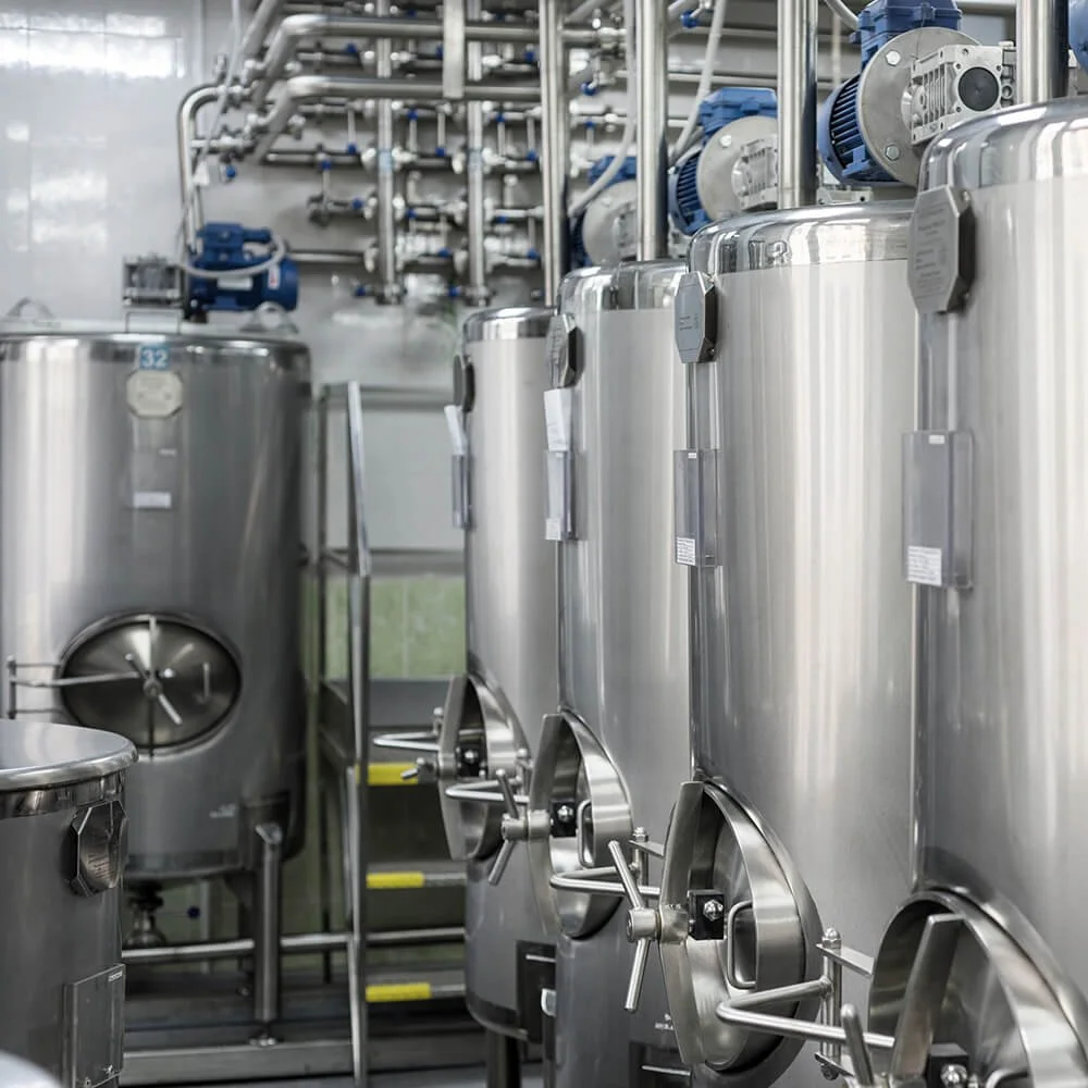 Industrial stainless steel tanks and machinery in a manufacturing or processing facility.