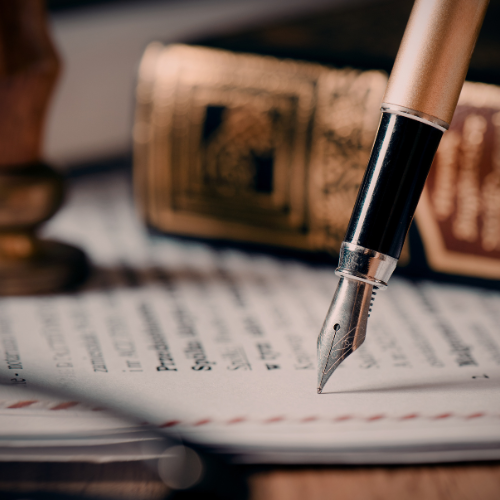 Close-up of a fountain pen writing on a document with blurred background of a stamp.