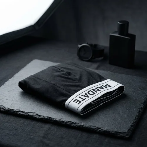 Folded black Mandate Signature Boxer Brief with a white logo waistband