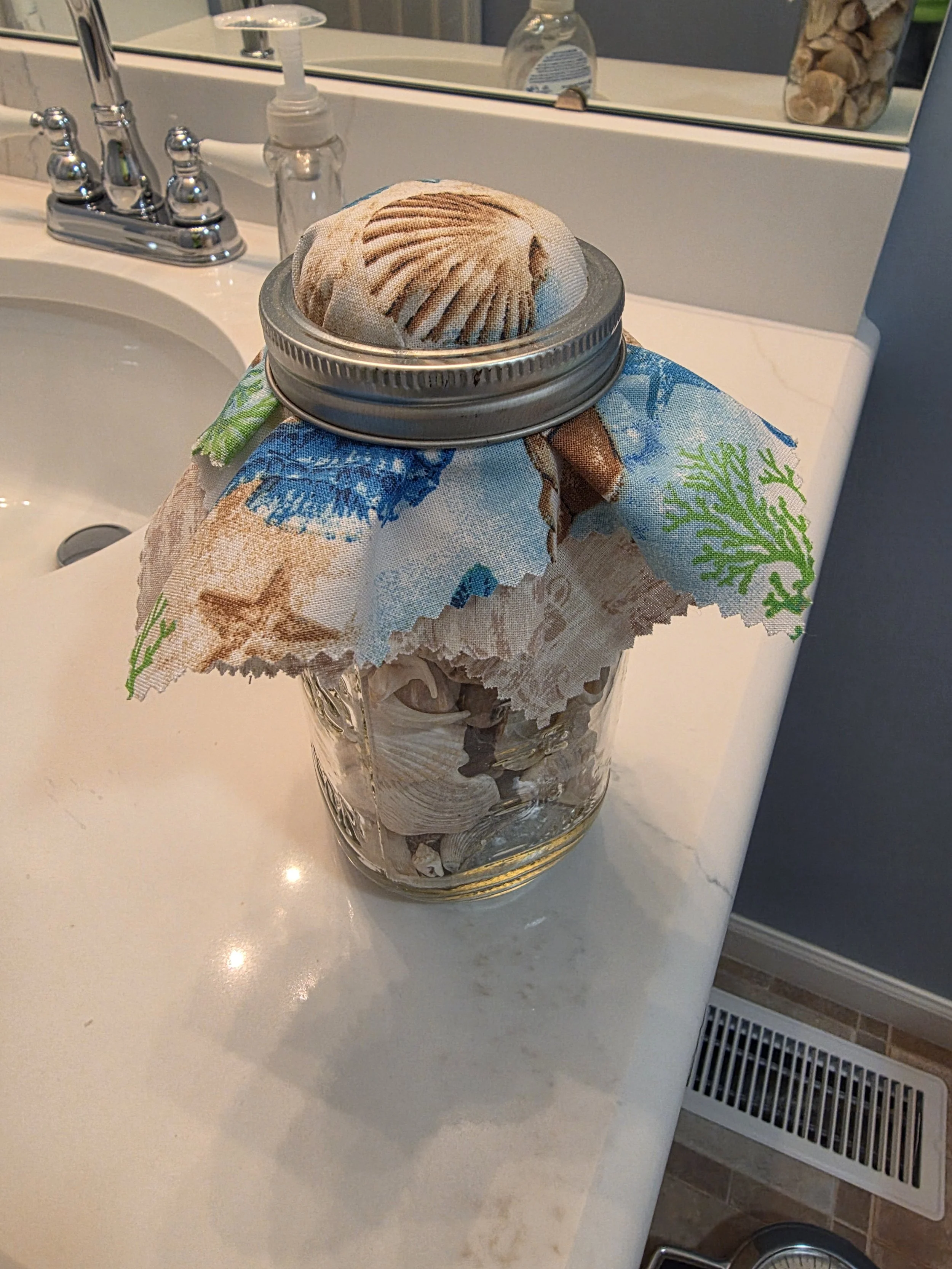 Adorable mason jar cover for a beach shell display
