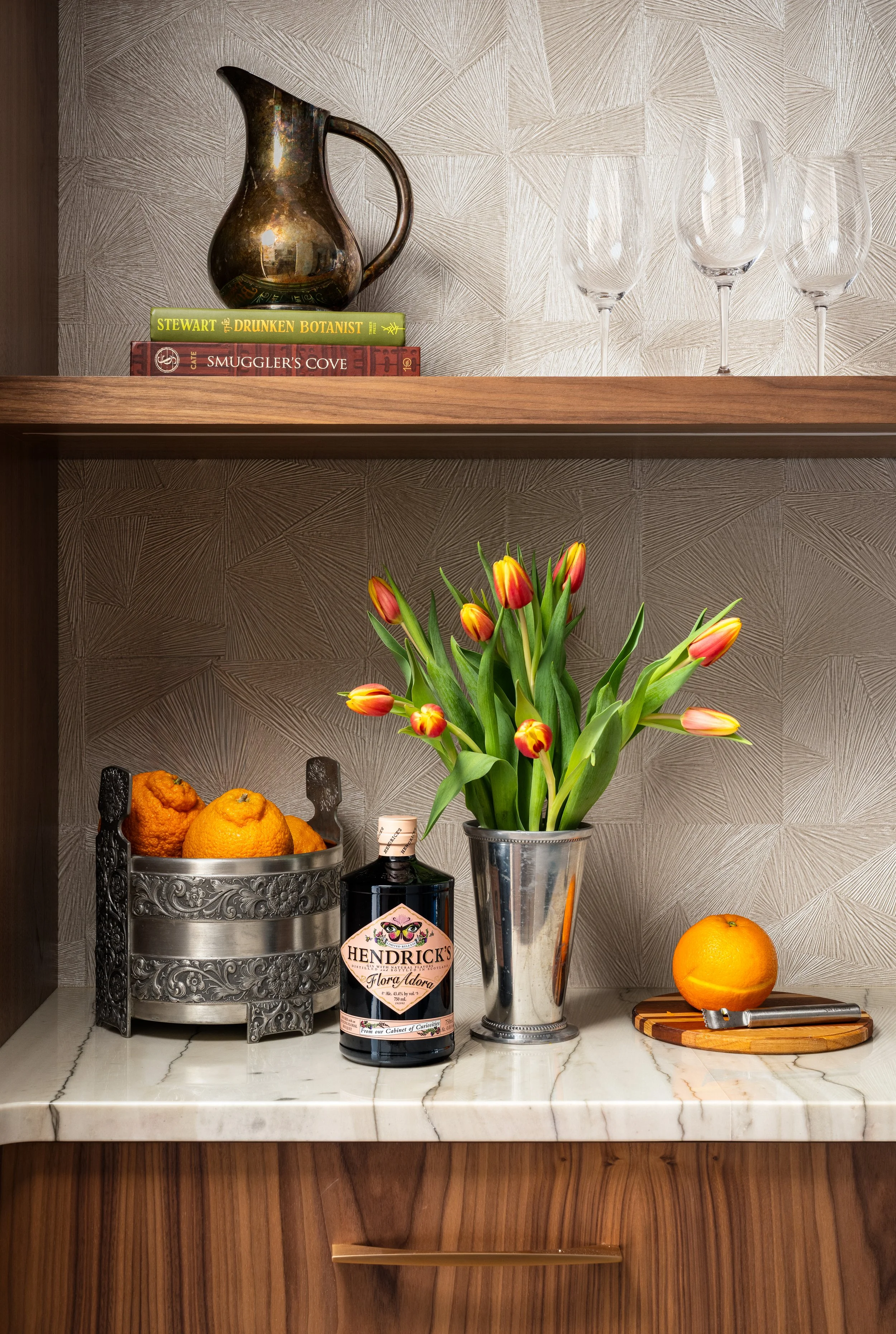 Bainbridge Island home bar nook featuring geometric textured wallpaper, Calacatta marble countertops, walnut wood shelving, and vintage silver accents.
