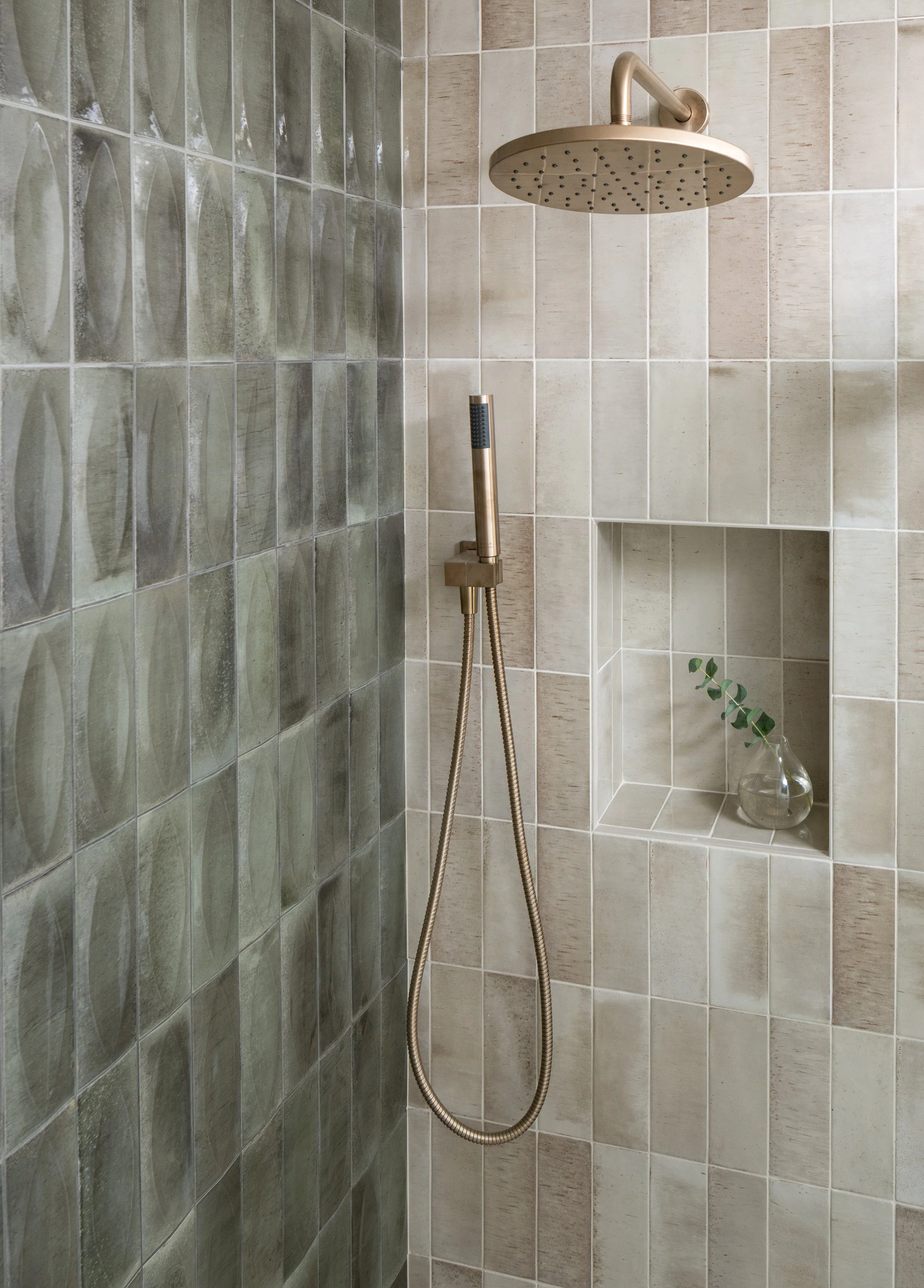 Bainbridge Island master bathroom featuring vertical stacked subway tiles, brushed brass rain shower head, and recessed wall niche.