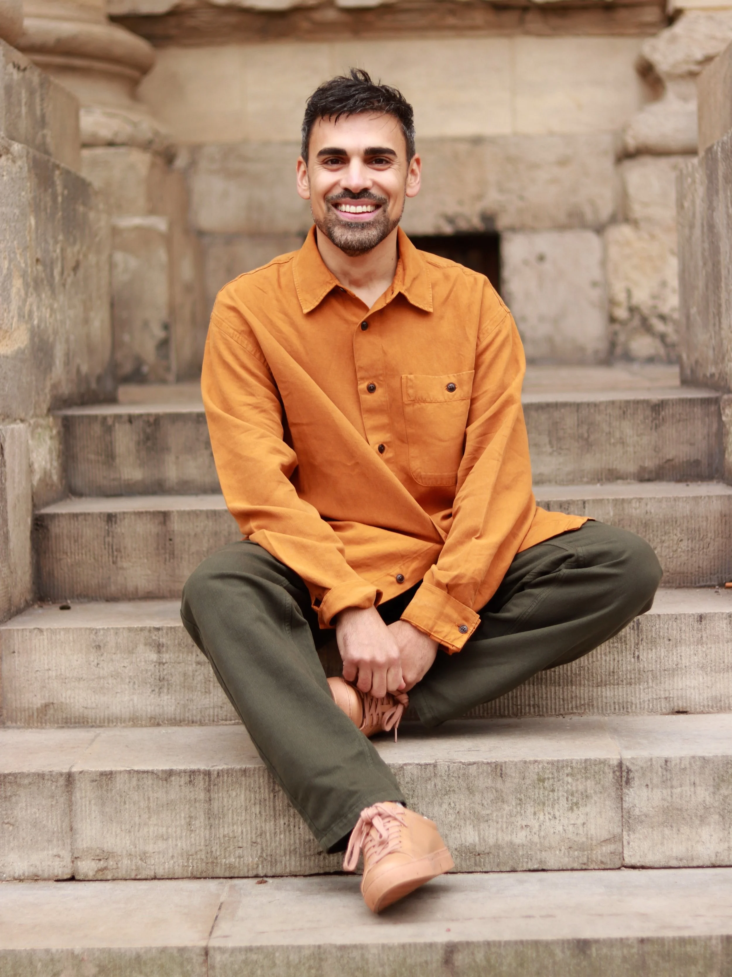 Miles Wrightman, psychotherapist in Oxford, sitting outside on stone steps.