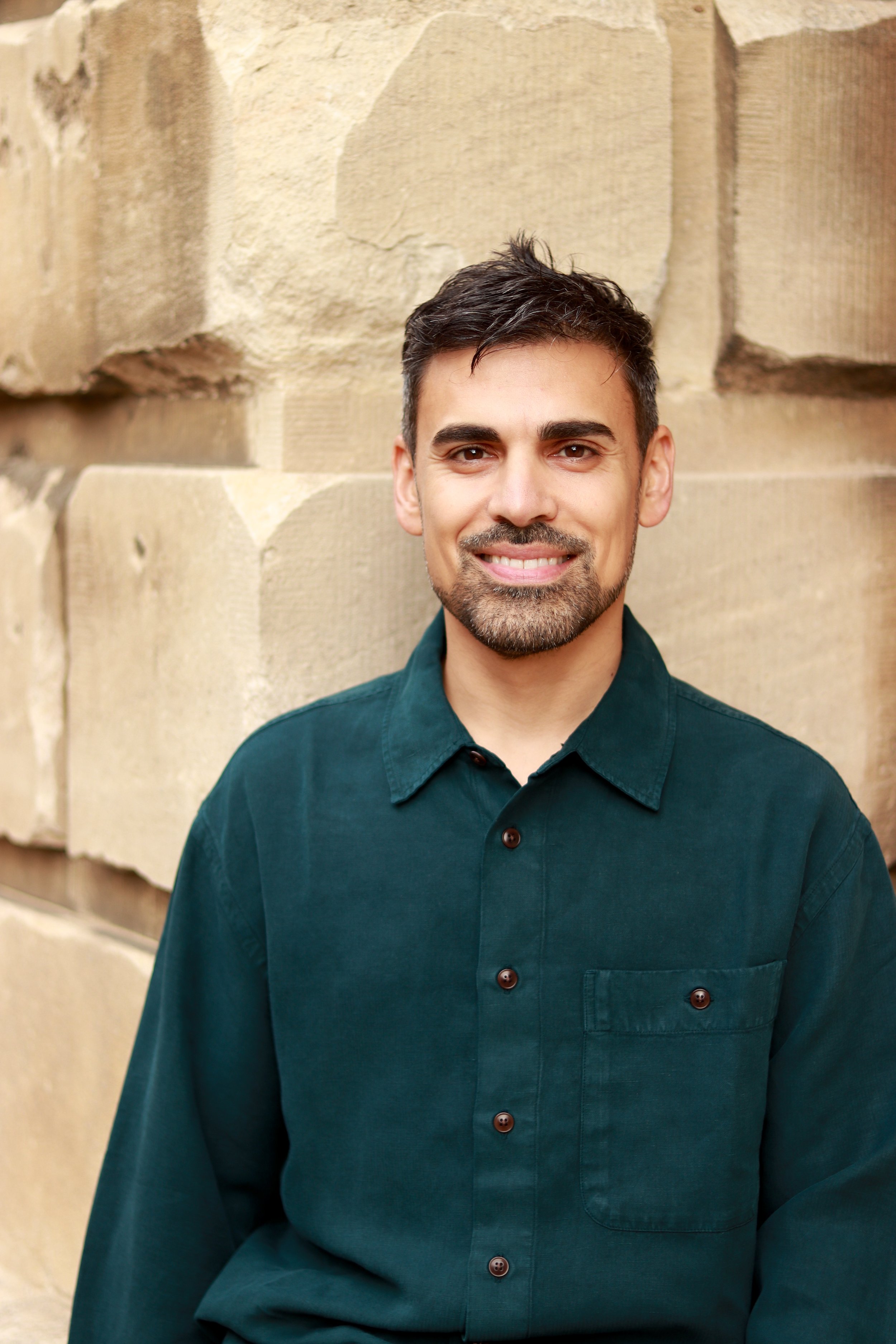 Miles Wrightman, psychotherapist in Oxford, standing outdoors against a stone wall.