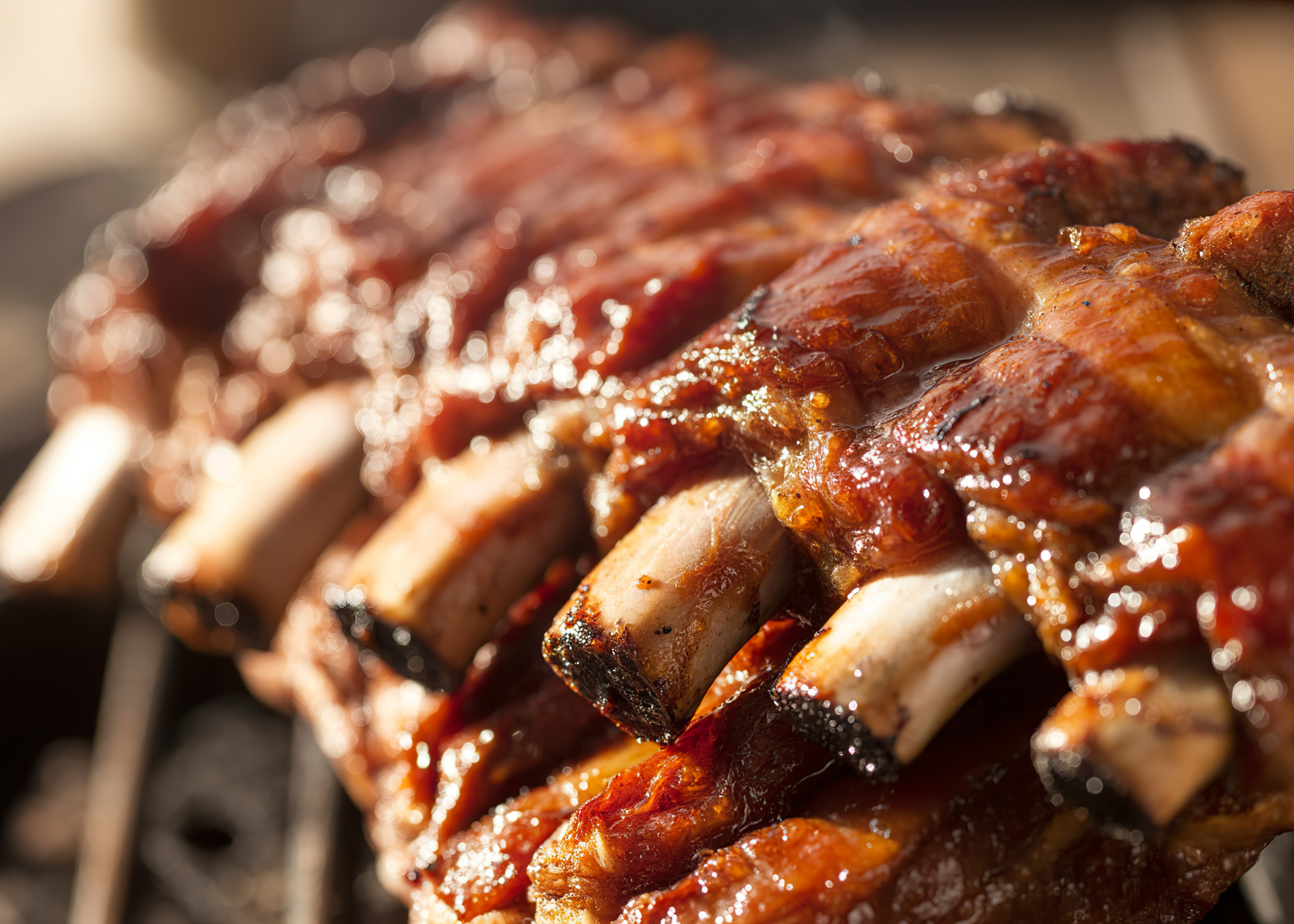 Close-up of grilled ribs covered in barbecue sauce.