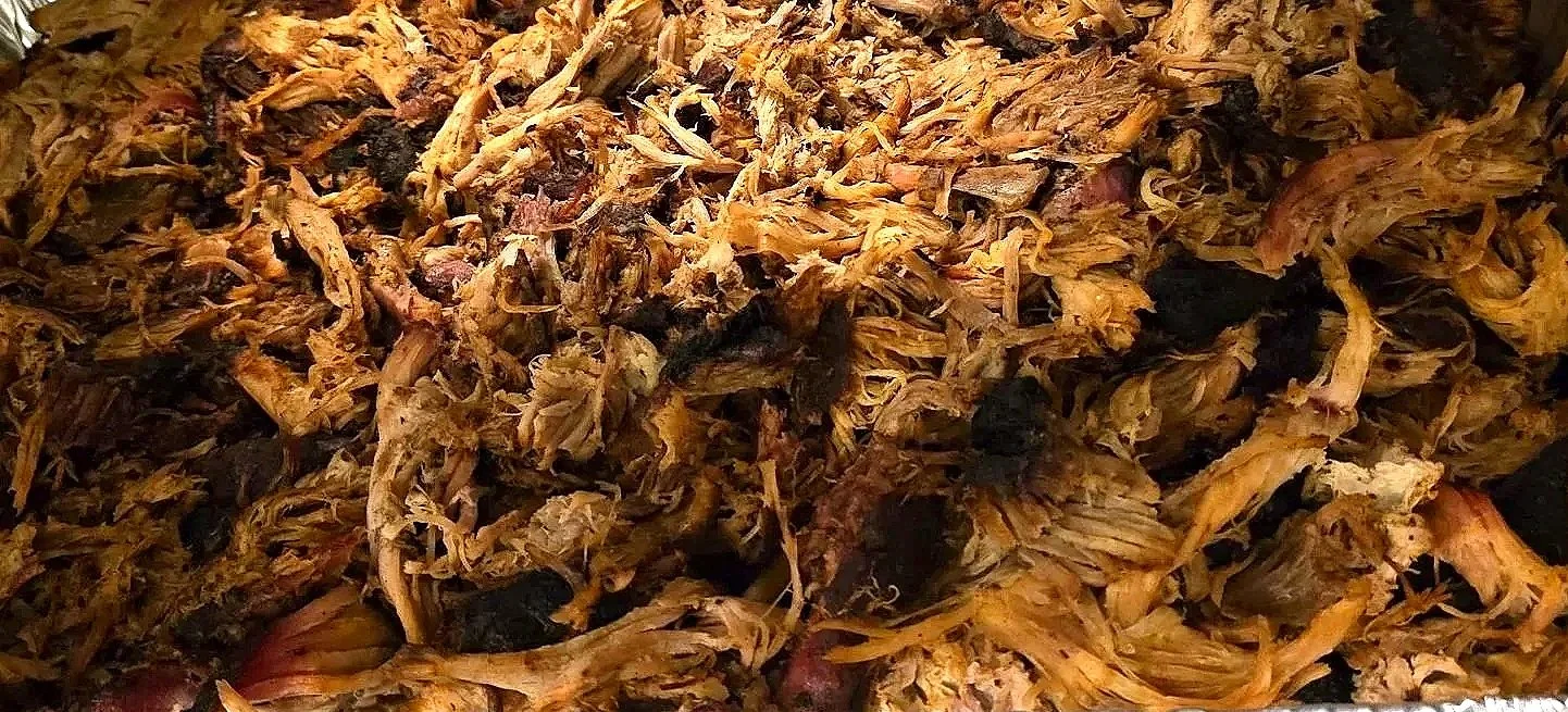 Close-up of shredded cooked meat, possibly pulled pork or chicken.