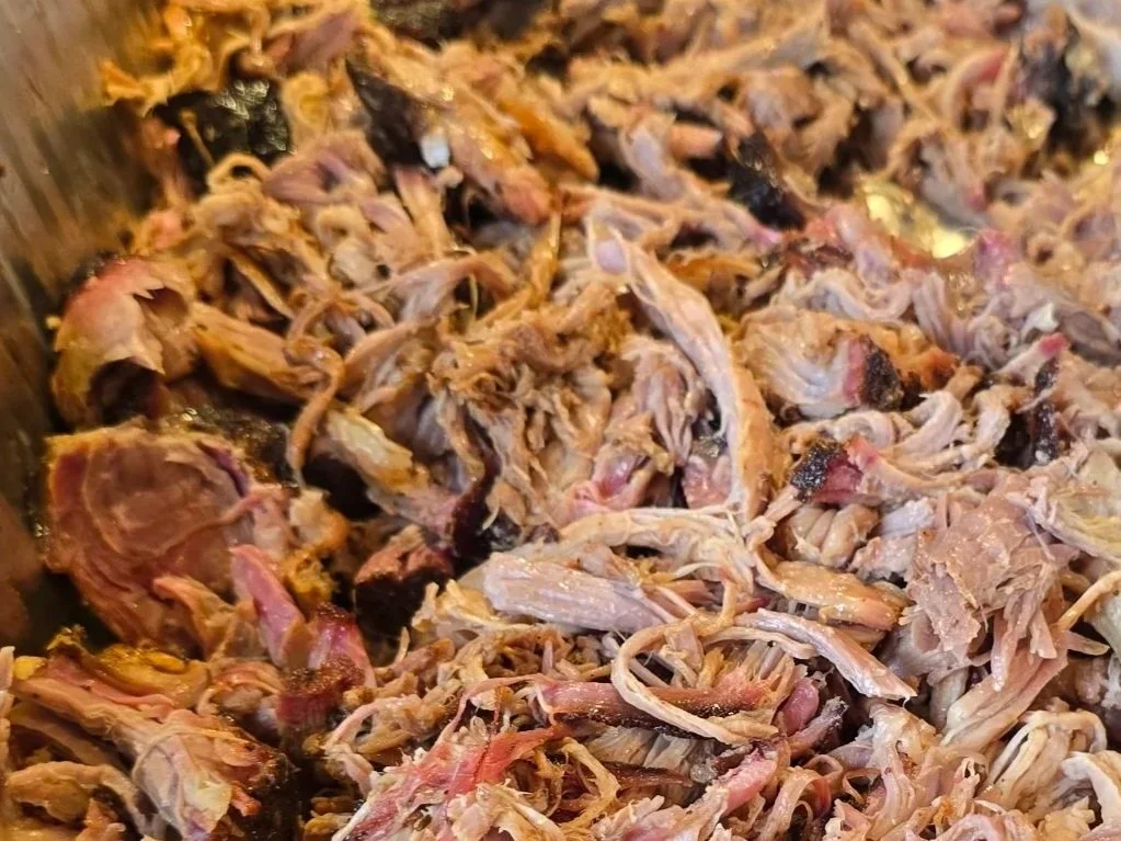 Shredded cooked meat, possibly pork or chicken, in a close-up view.