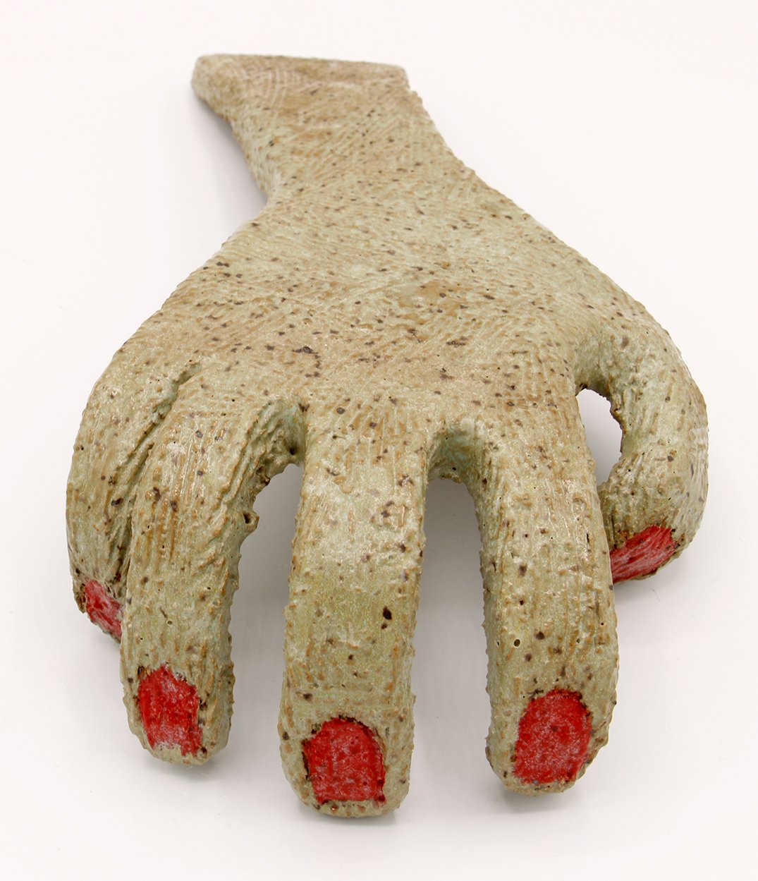 A beige, textured object in the shape of a hand with four fingers and a thumb, with red paint on the fingertips, set against a plain white background.