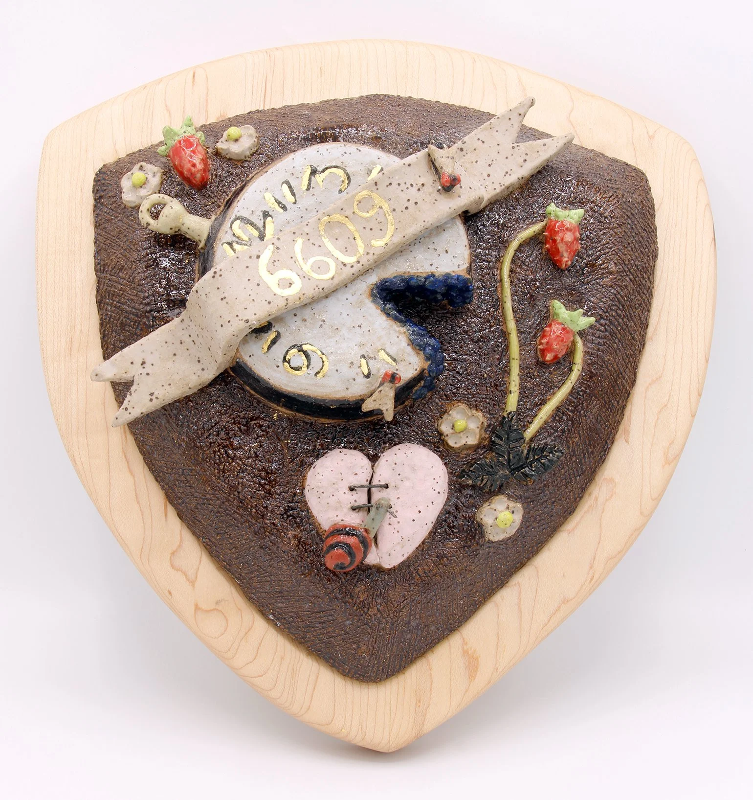 Heart-shaped cake decorated with a clock, a flying bird, strawberries, and small flowers.