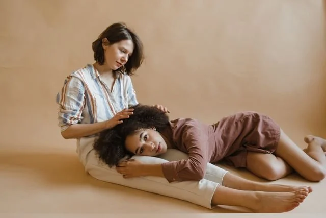 woman laying on other woman's lap