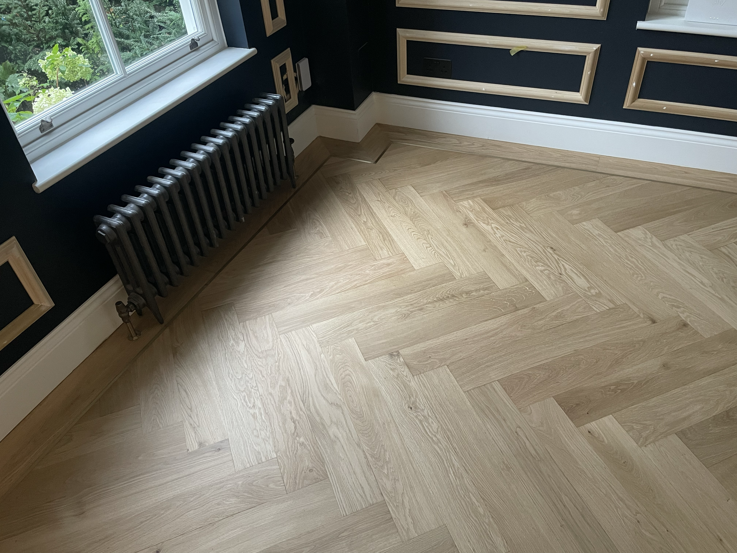 Oak herringbone with brass boarder detail. 