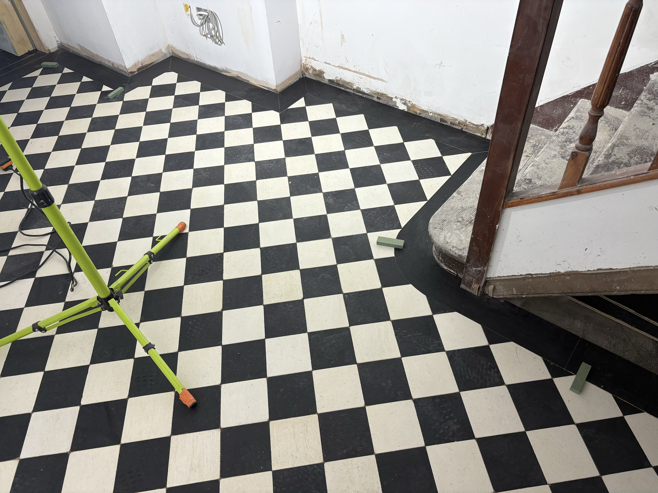 Bespoke checkerboard squares with plank curved boarder installation. Central London tailors shop. 