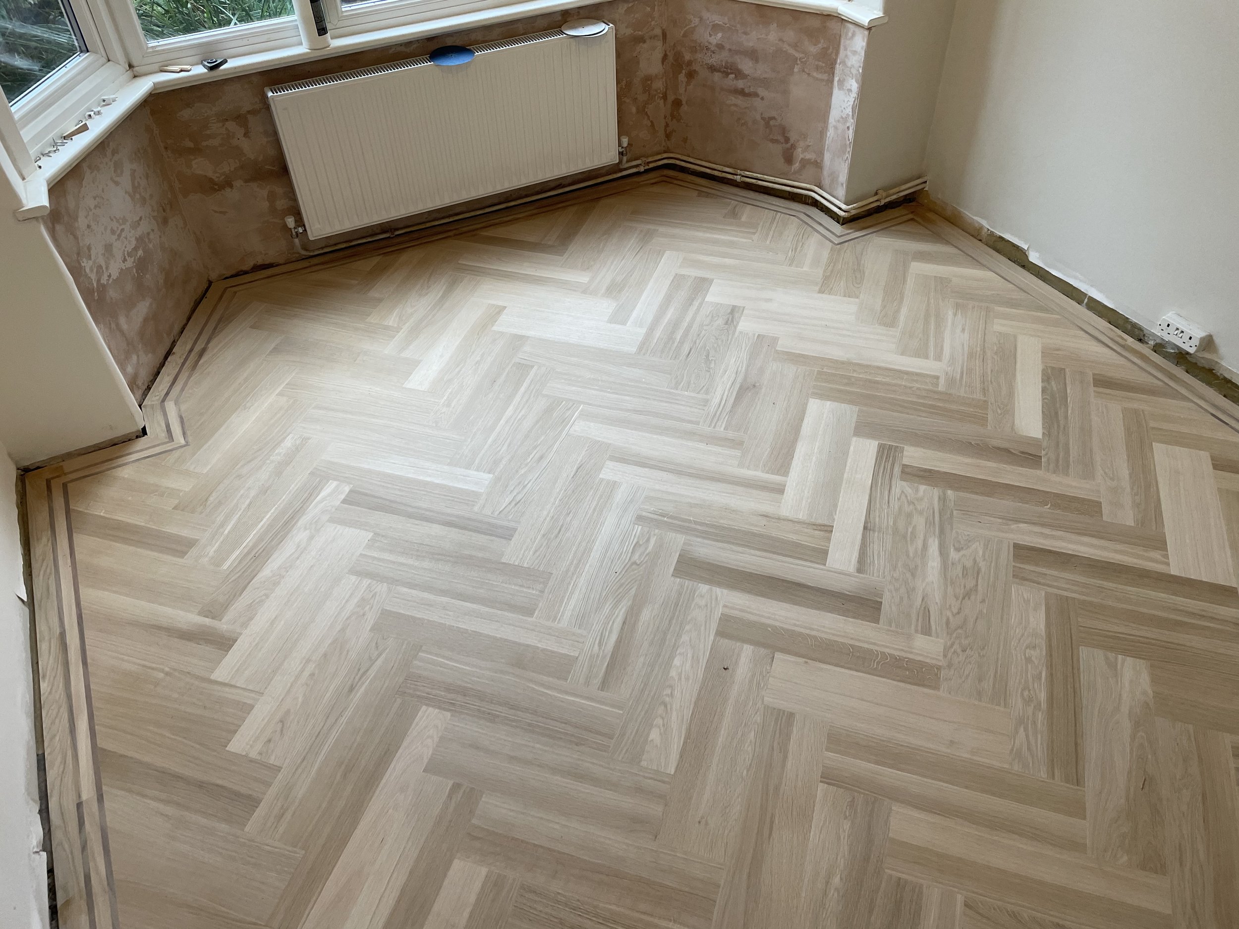 Double herringbone with walnut pin strip boarder. Kentish Town. 