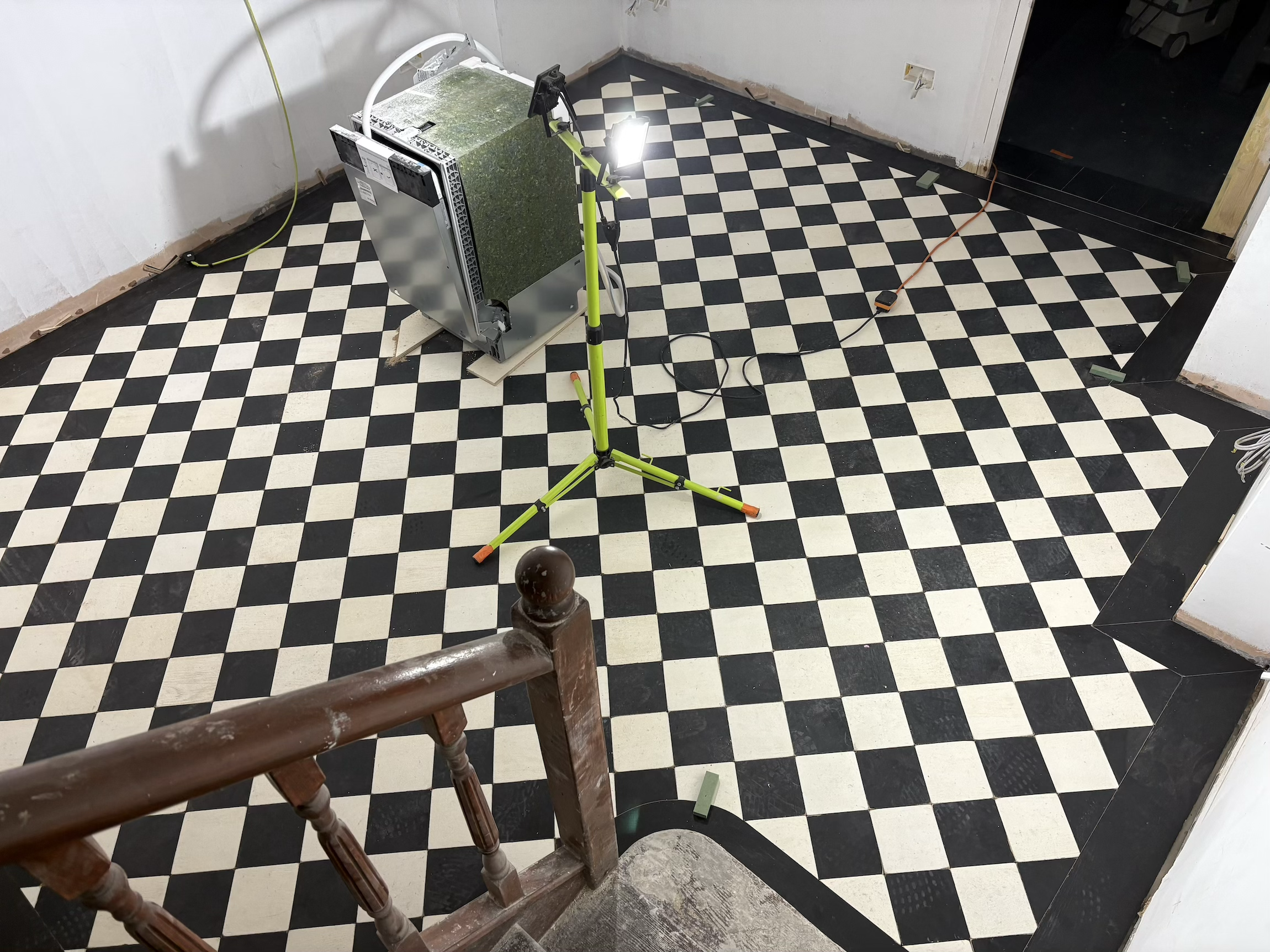 Bespoke checkerboard squares with plank boarder installation. Central London tailors shop. 